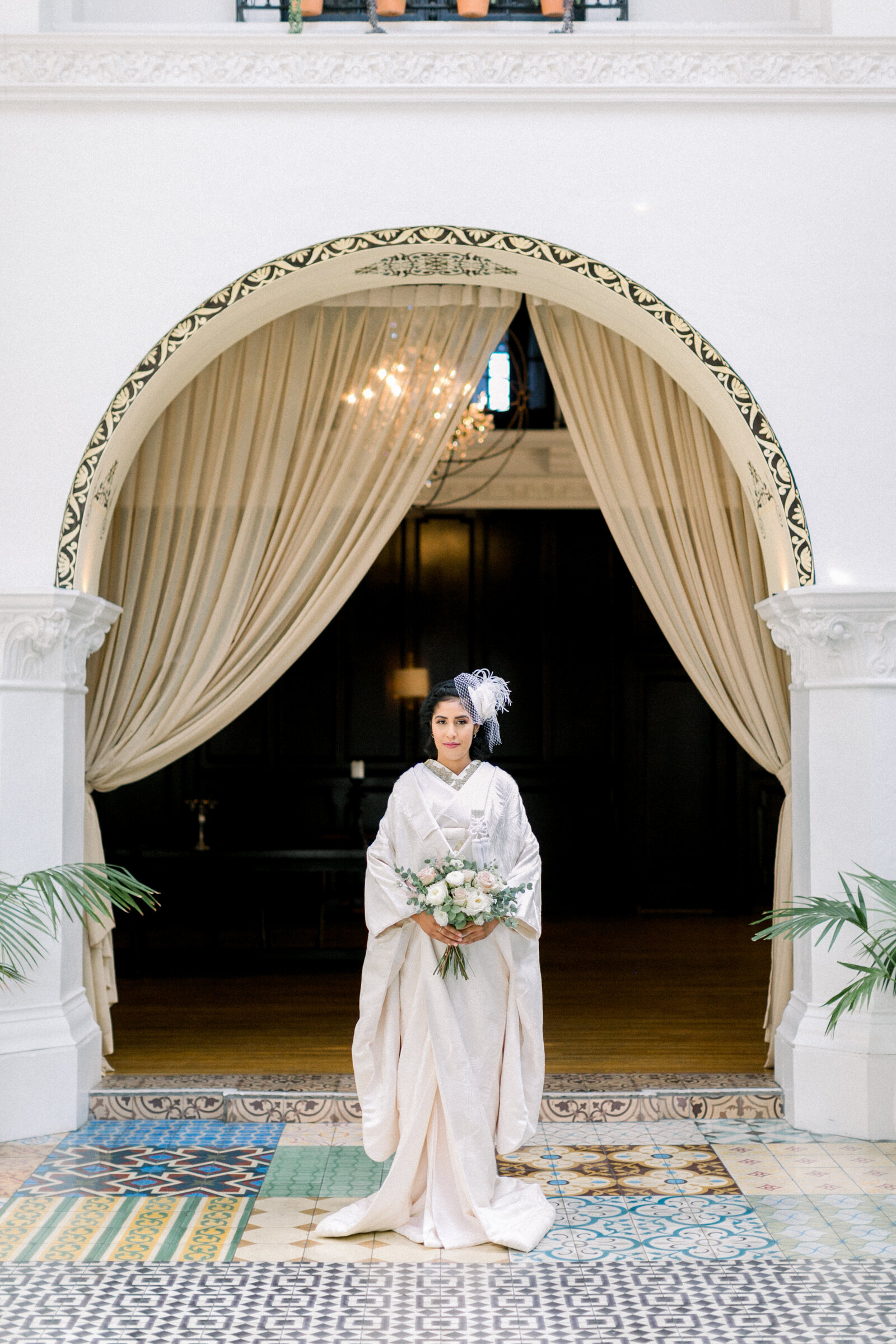 Bride standing beneath elegant archway wearing white shiromuku wedding kimono at The Ebell Club Long Beach, Los Angeles California, perfect for wedding kimono rental | アーチ下に立つ白無垢花嫁 エベルクラブ ロサンゼルス カリフォルニア　着物レンタル可能