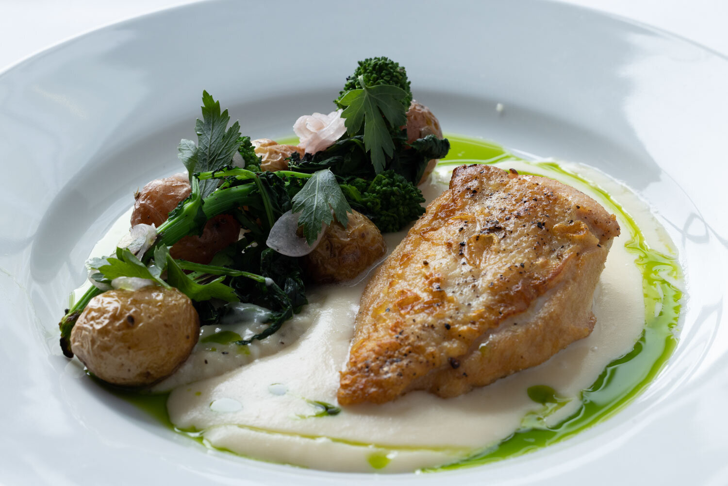 Seared chicken breast with greens, potatoes, and creamy sauce