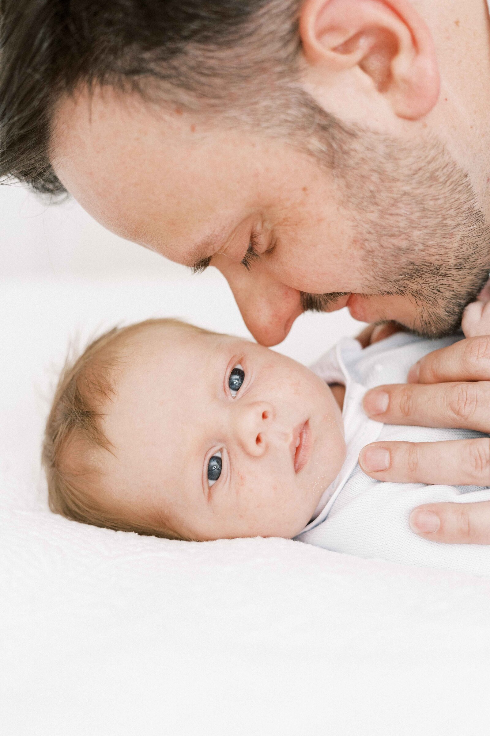 baby looking at camera, dad snuggling baby in peoria illinois newborn photos 