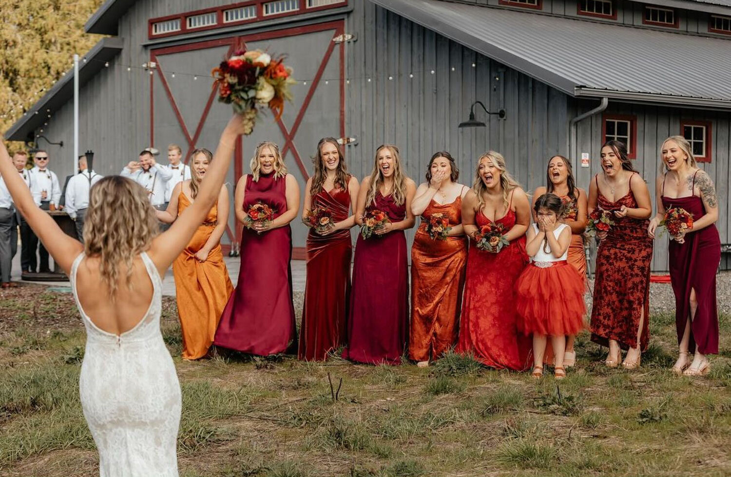 A bride tossing her bouquet to a cheering group of bridesmaids