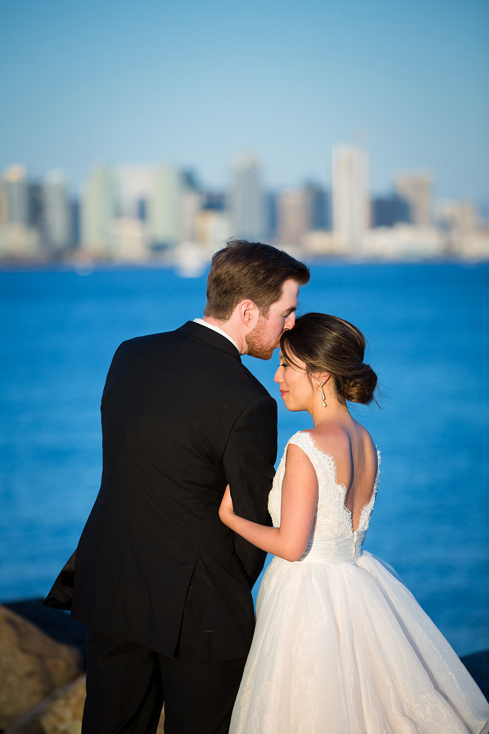 groom kissing brides head