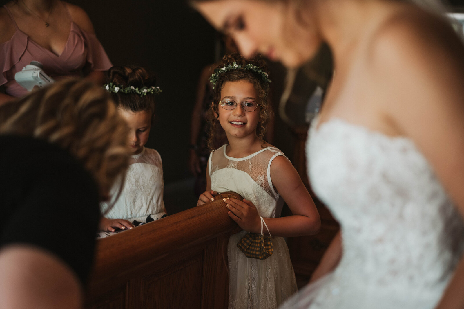 Flower girl admires bride as she gets ready for her wedding.