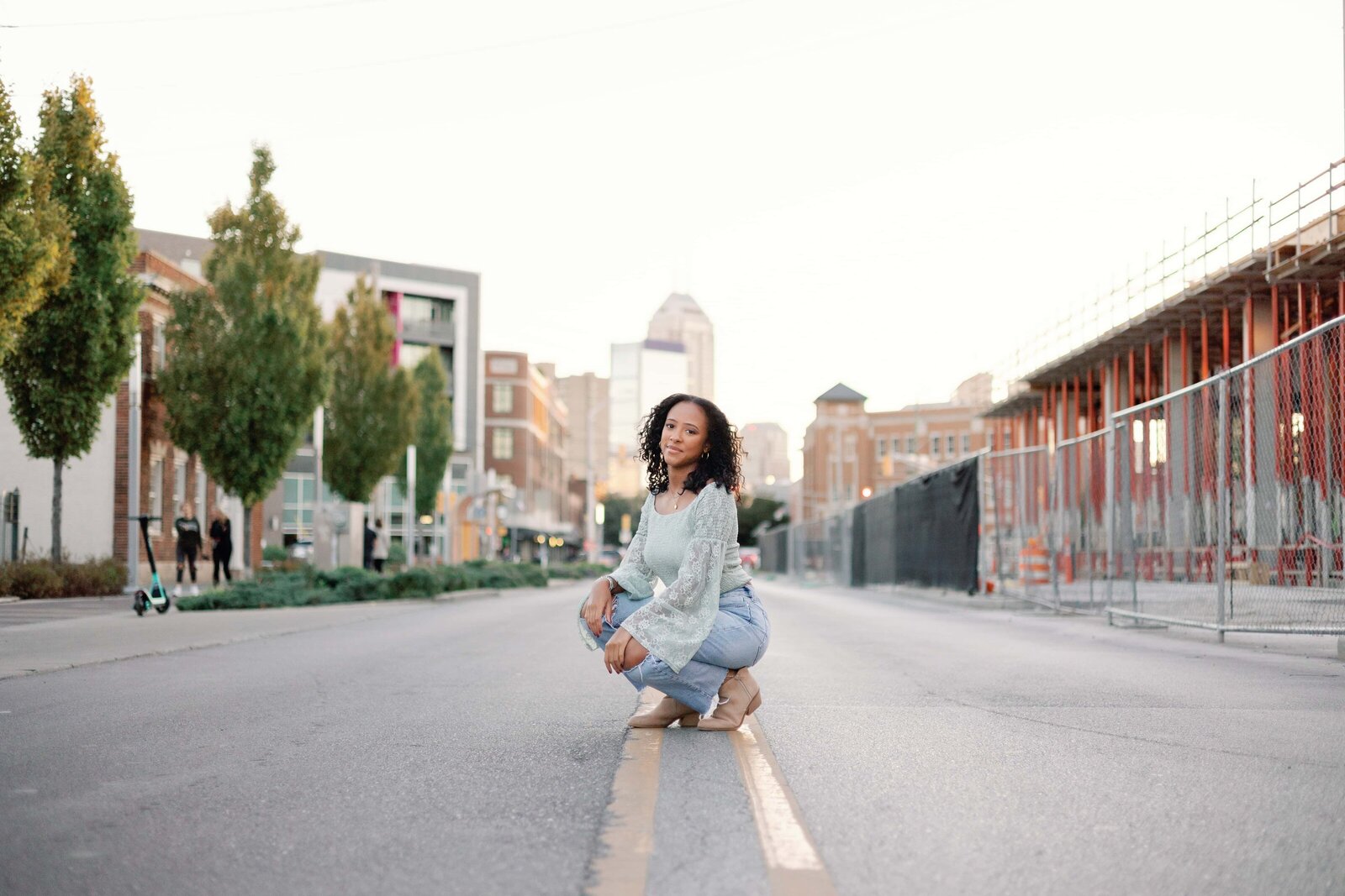 Girl senior photo kneeling on Indianapolis street
