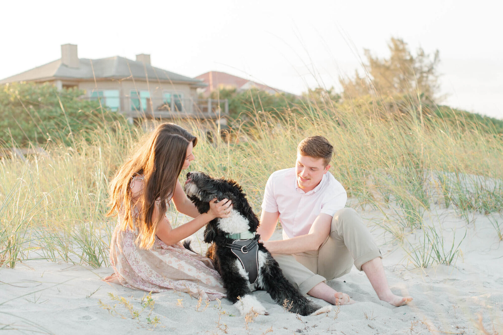 Orlando couple playing with their dog near the dunes on Cocoa Beach east of Orlando at sunset during their photoshoot