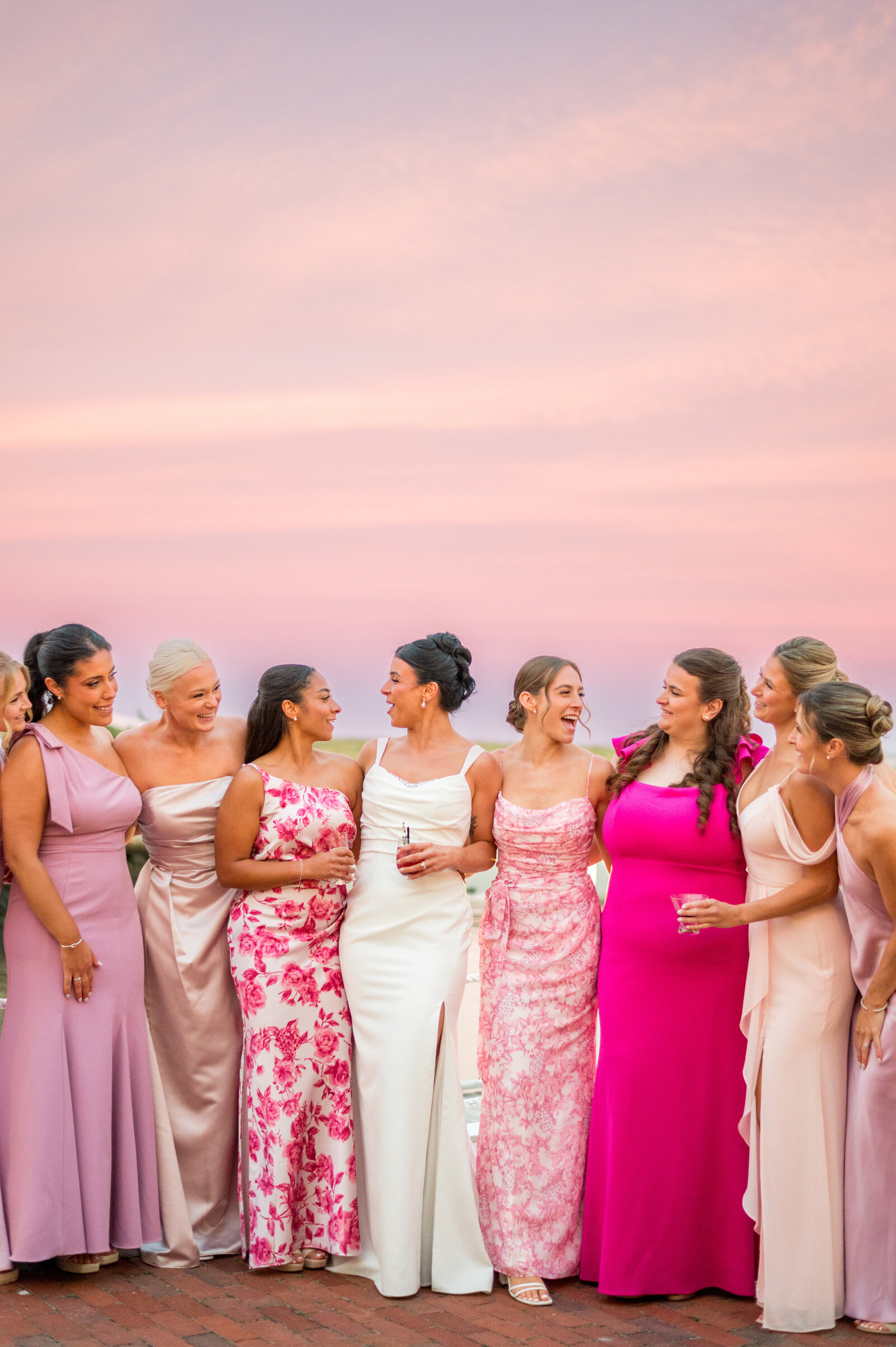 Bridesmaids in pink and floral dresses at sunset during coastal New England wedding at Wychmere Beach Club by Sarah Surette Photography