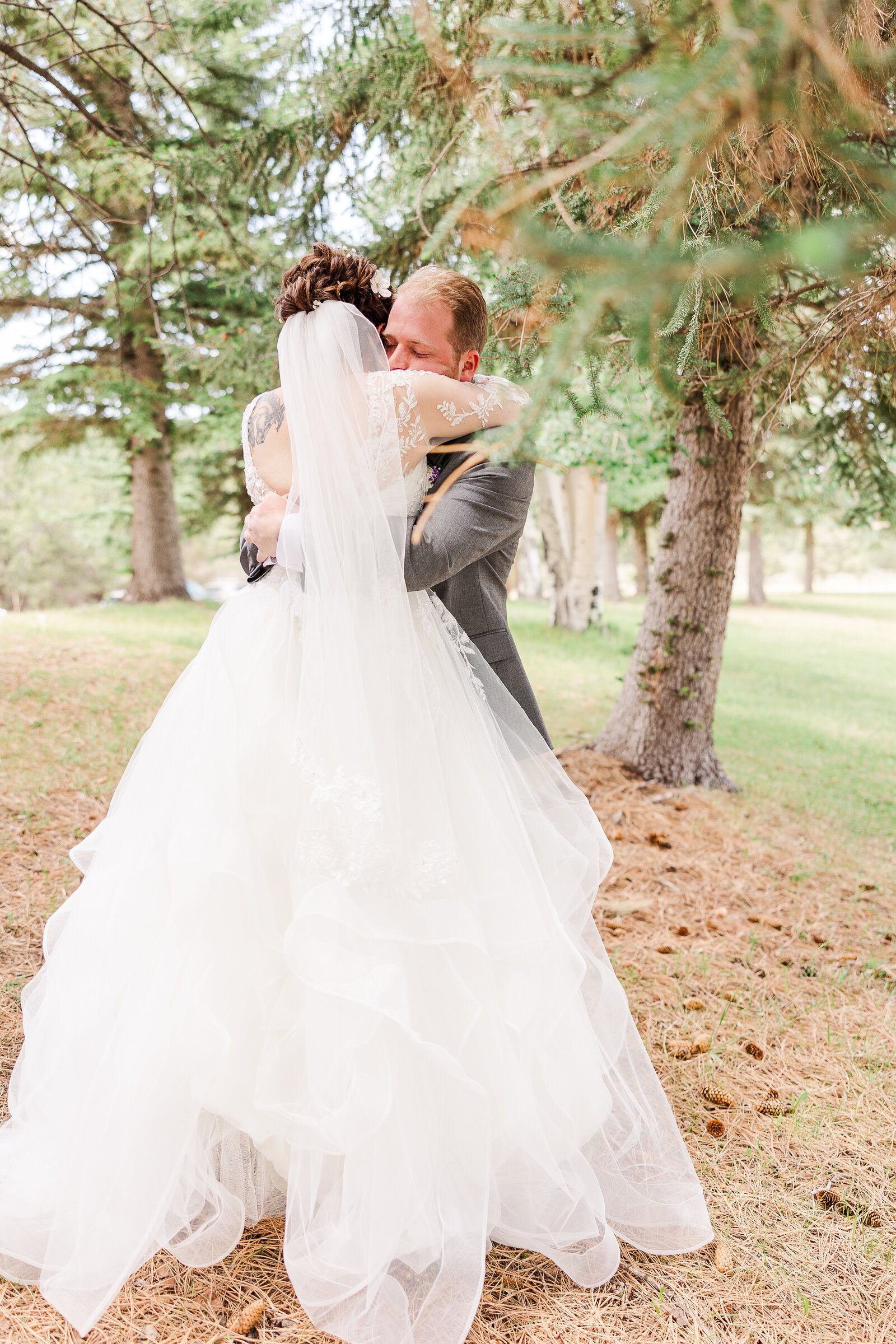 Bride and groom sharing a tender hug during their first look at Ridgway State Park, filled with love and anticipation.