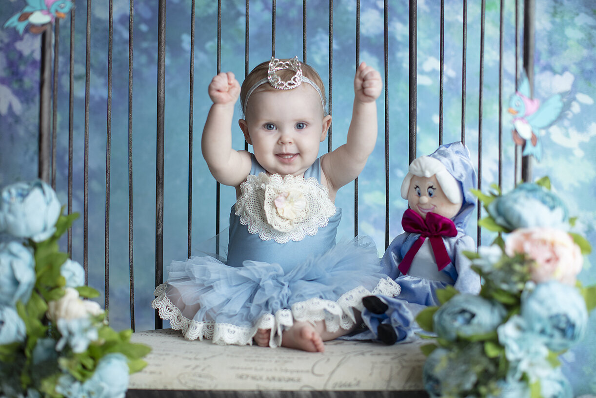 Baby girl laughing at Cinderella cake smash, a Dallas cake smash photographer.