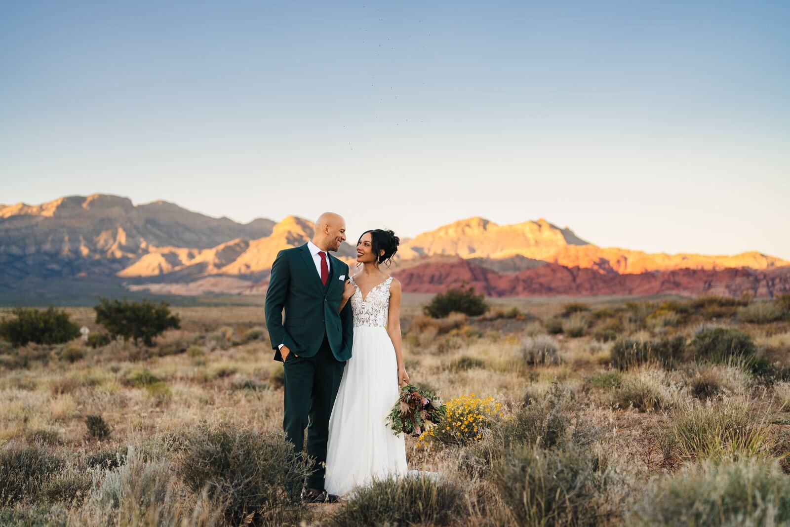 Newlywed couple sharing an intimate moment at Red Rock Canyon in Las Vegas during their elopement.