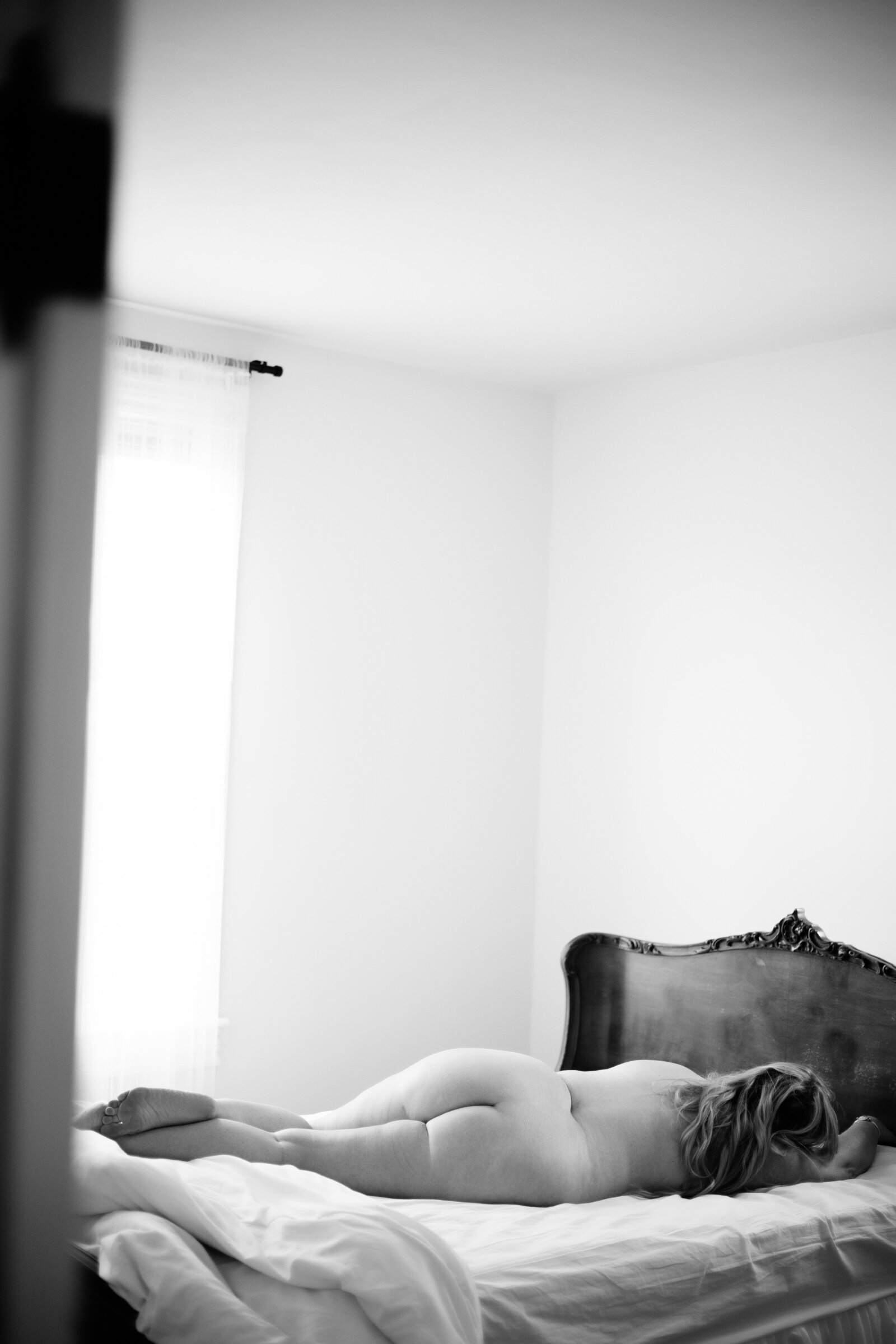 Black and white boudoir photo of woman lying on a bed