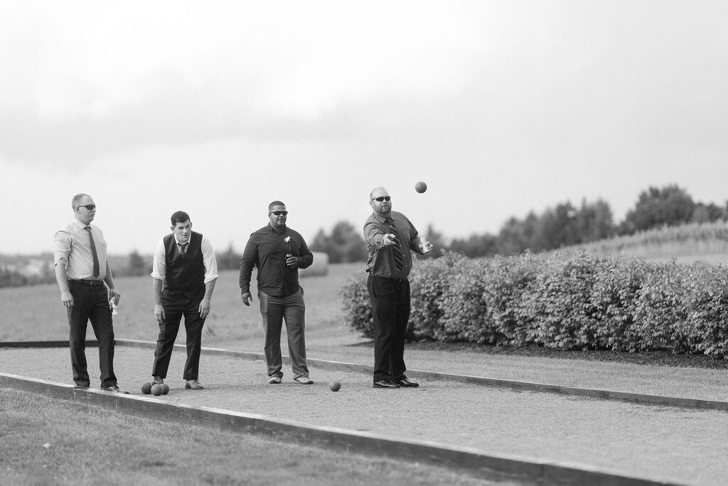 black and white photo of wedding guests playing bocci outdoors at Windridge Estate