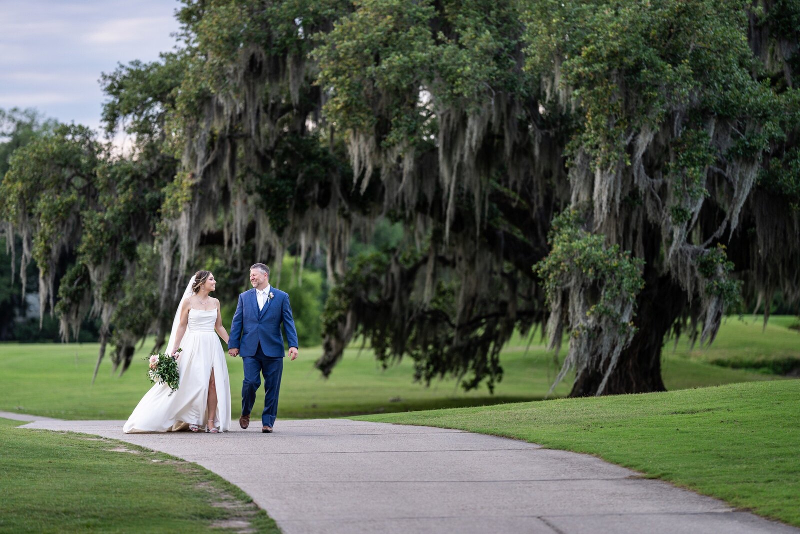 Couple walking along path at Audubon Golf Clubhouse wedding