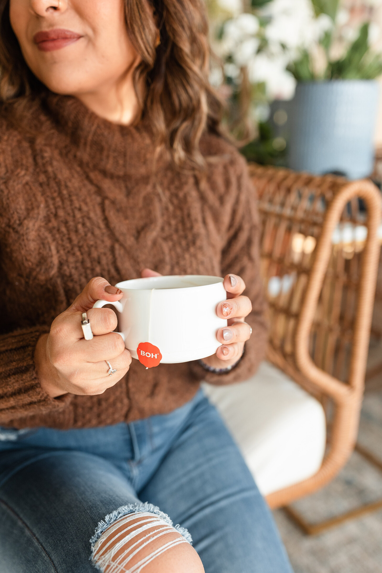 woman softly smiling holding mug of hot tea