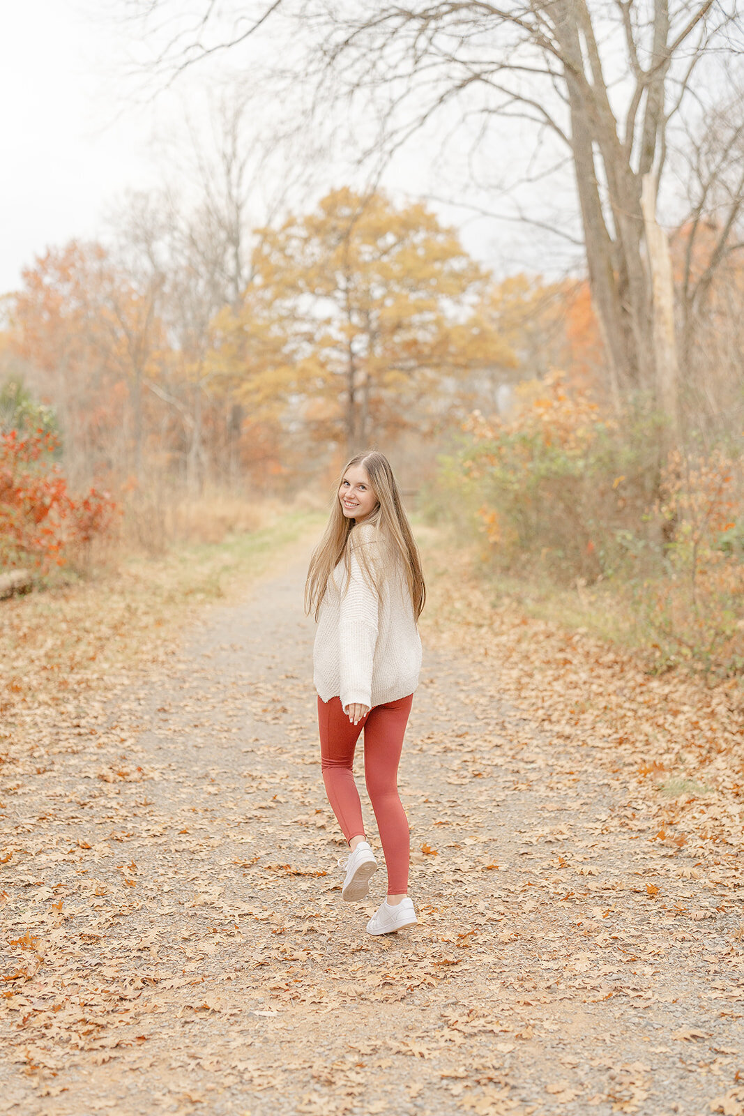 girl skipping during Alexandria, VA senior photo in fall