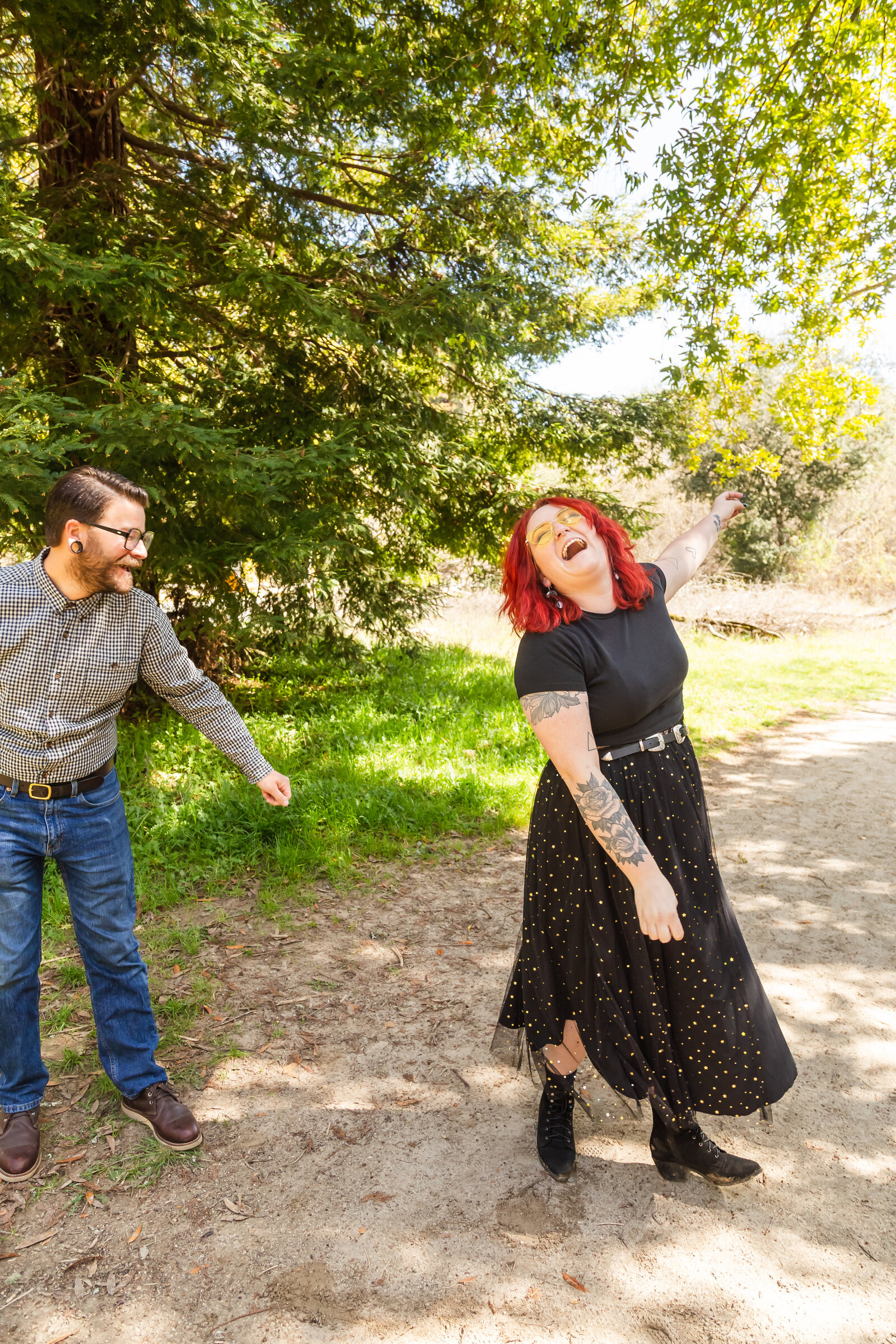 An tattooed engaged couple poses for photos in a redwood forest in Santa Cruz, Ca.