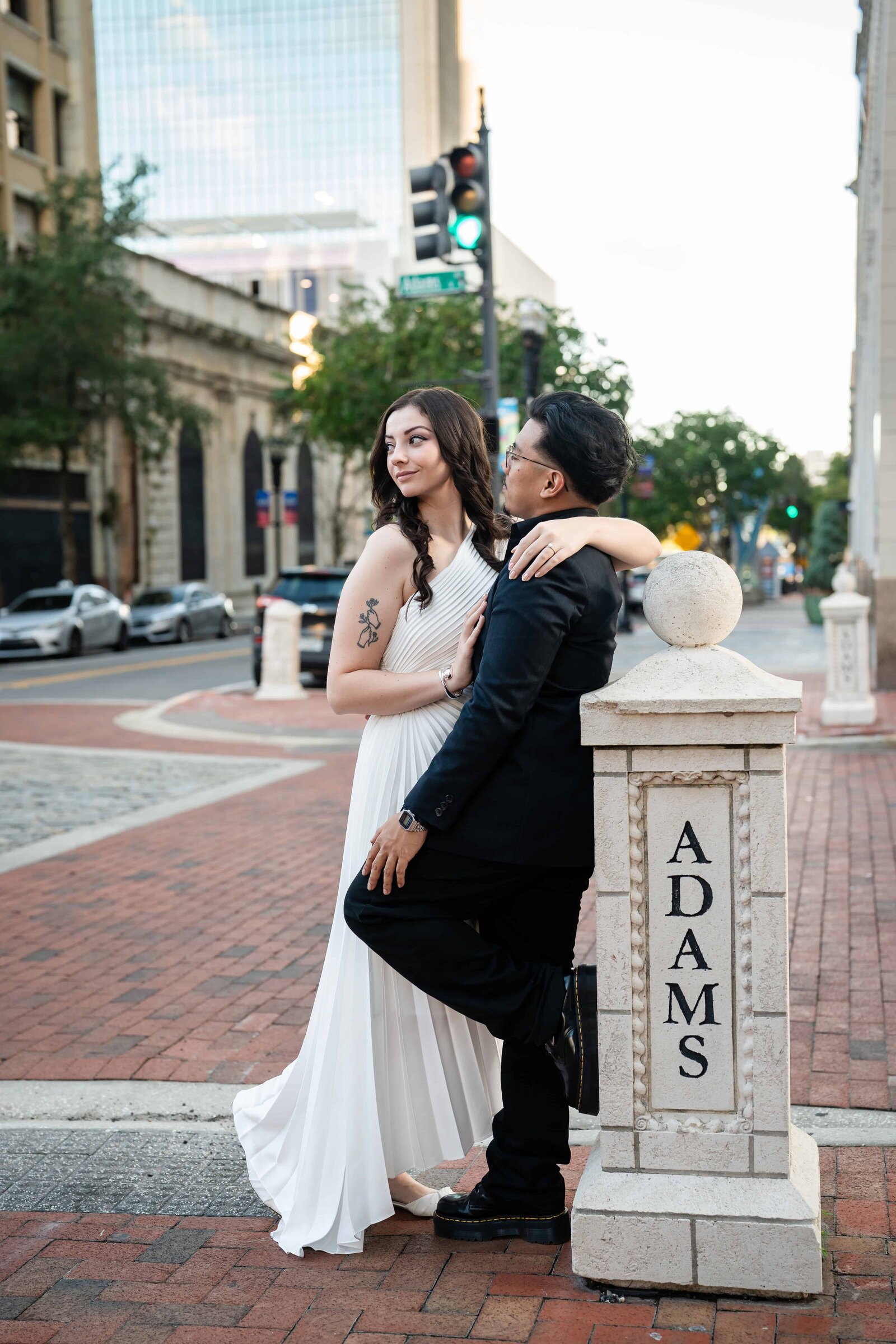 Bride in long white dress, groom in all black for engagement photos