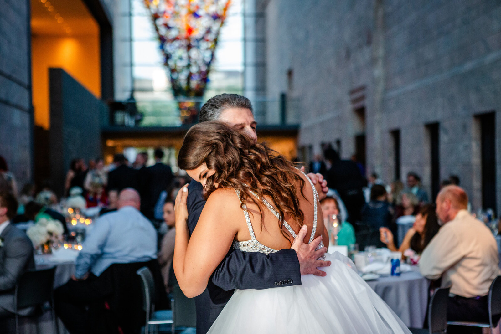 Bride dancing with her father with chihuly in the background