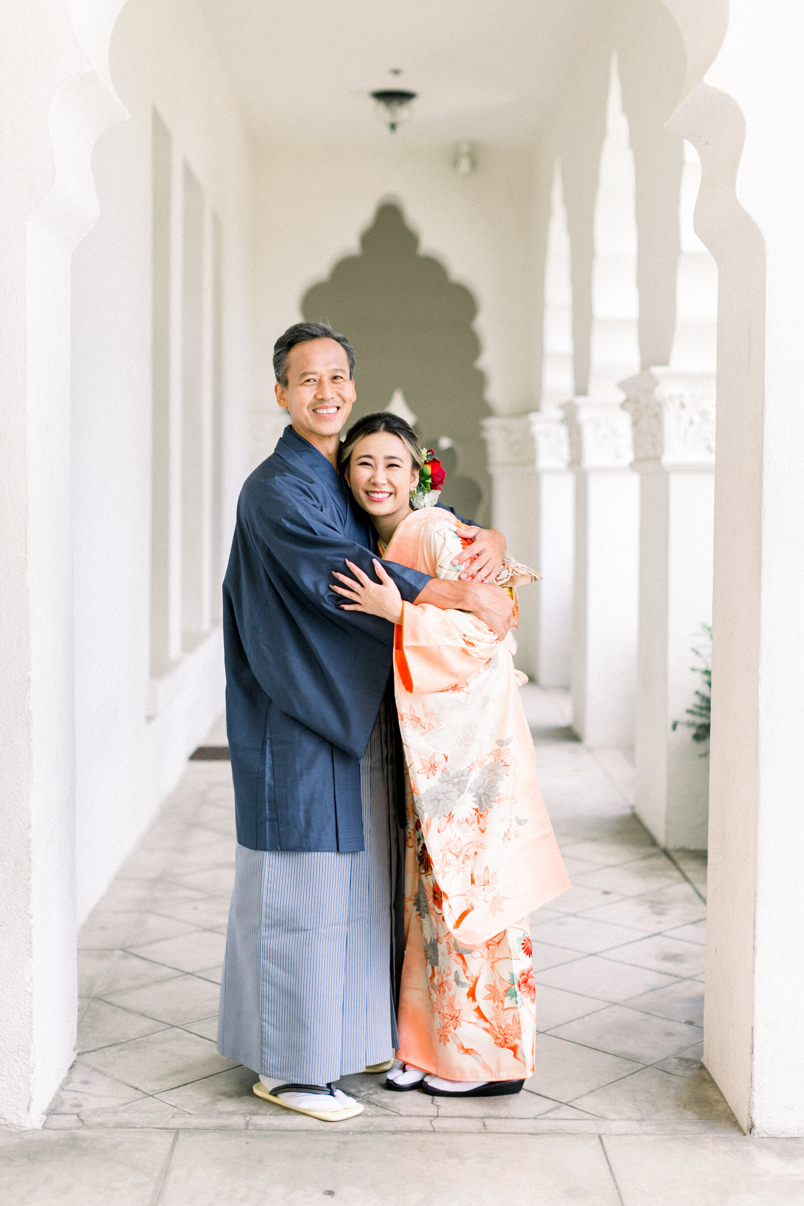 Heartwarming father–daughter hug during Seijinshiki (coming-of-age) photo session at Brand Park Glendale, daughter in peach furisode, kimono rental Los Angeles | ロサンゼルス・ブランドパークでの成人式撮影、淡いオレンジ振袖の娘とお父様の温かいハグ、着物レンタル