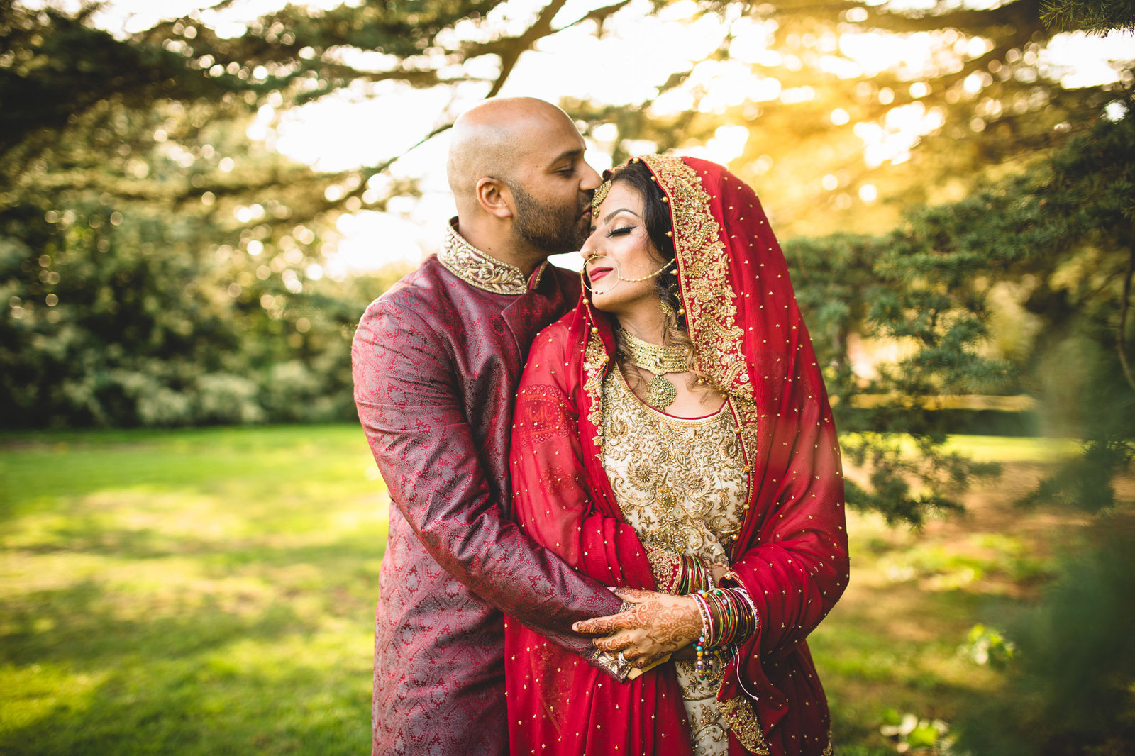 a muslim bride and groom kissing in evening light