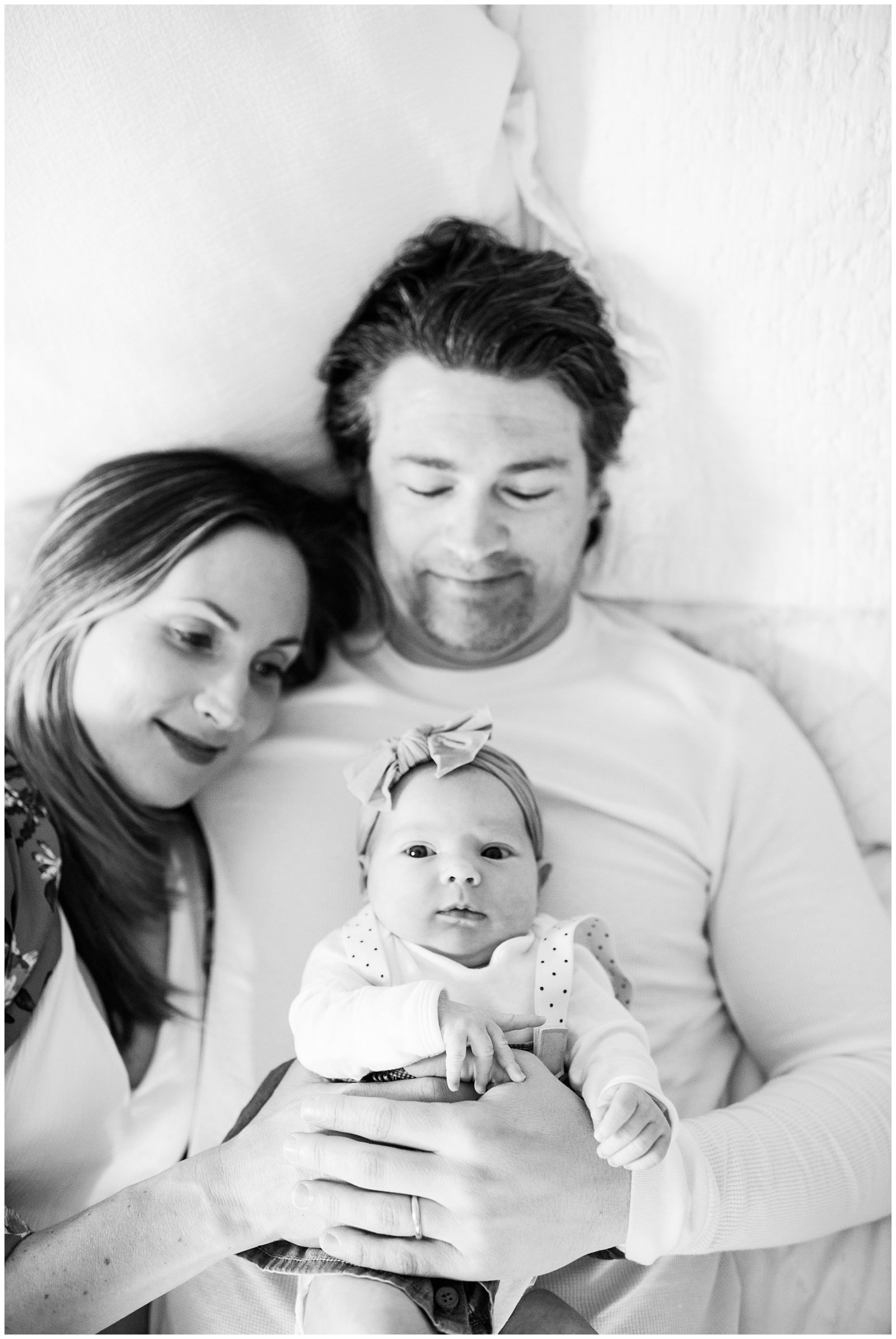 black and white mom and dad holding baby on bed Emily Ann Photography Seattle Photographer