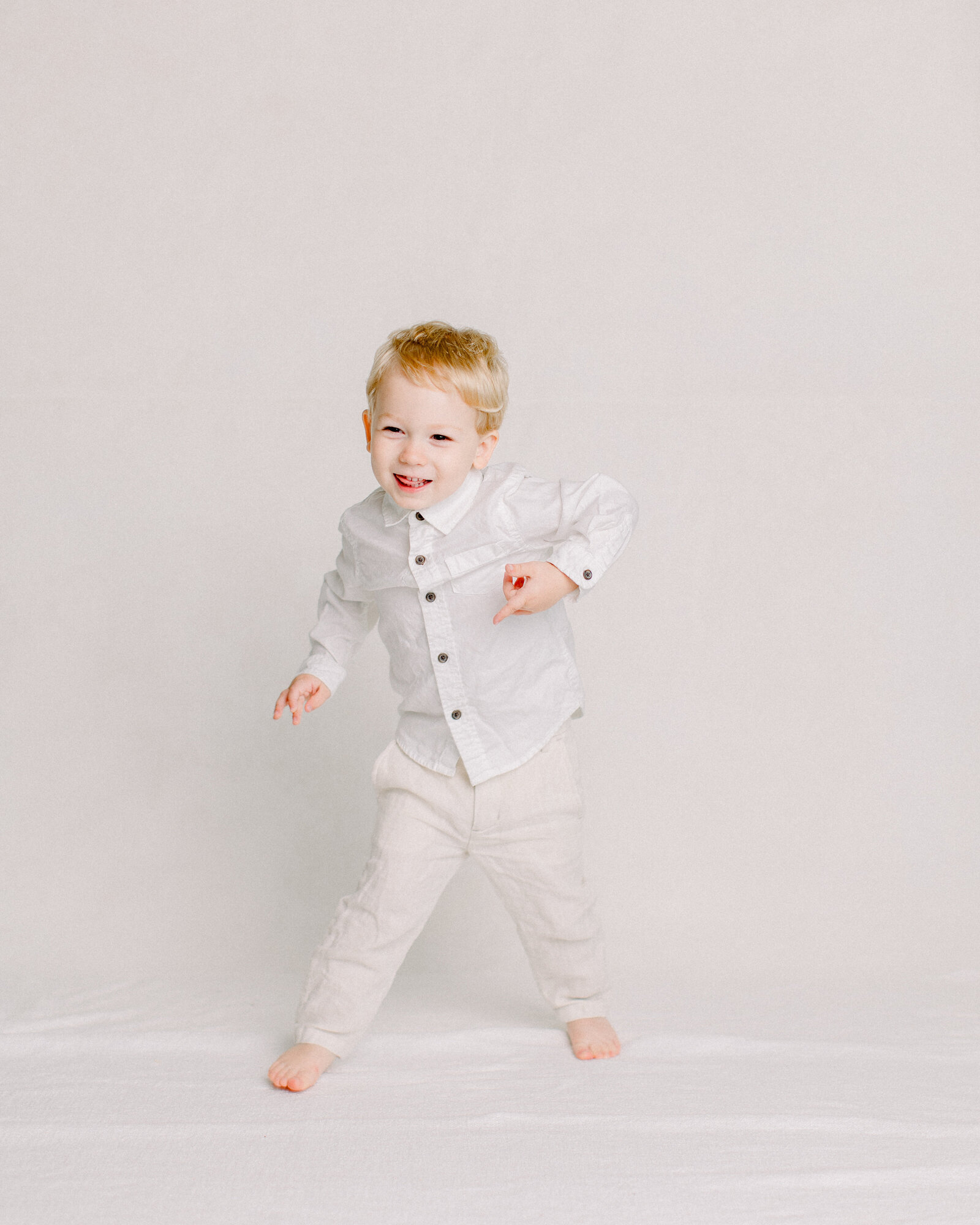 Silly toddler dancing in a neutral studio by NH newborn photographer Fieldstone Studio.
