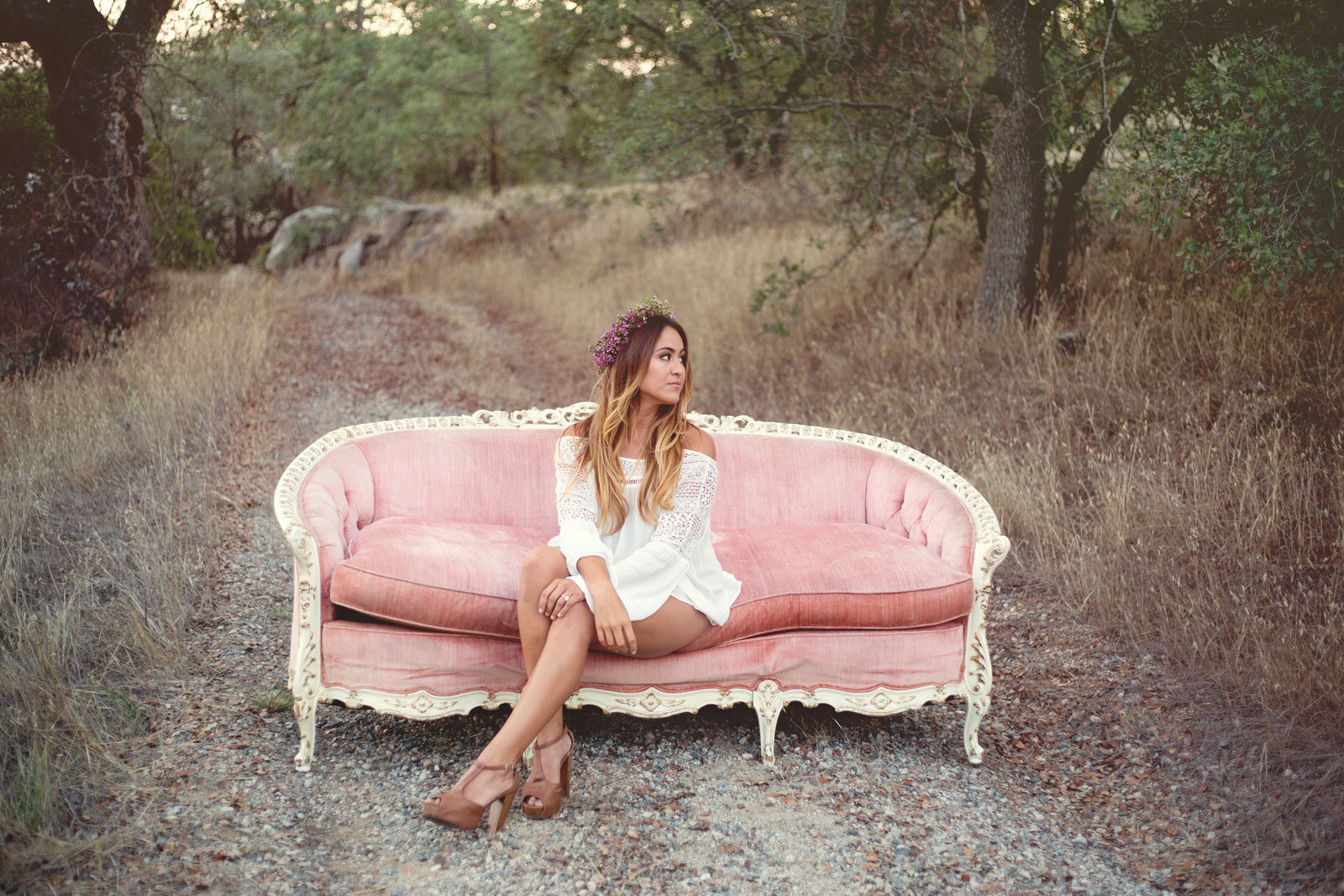 Woman sitting on pink sofa outside in nature