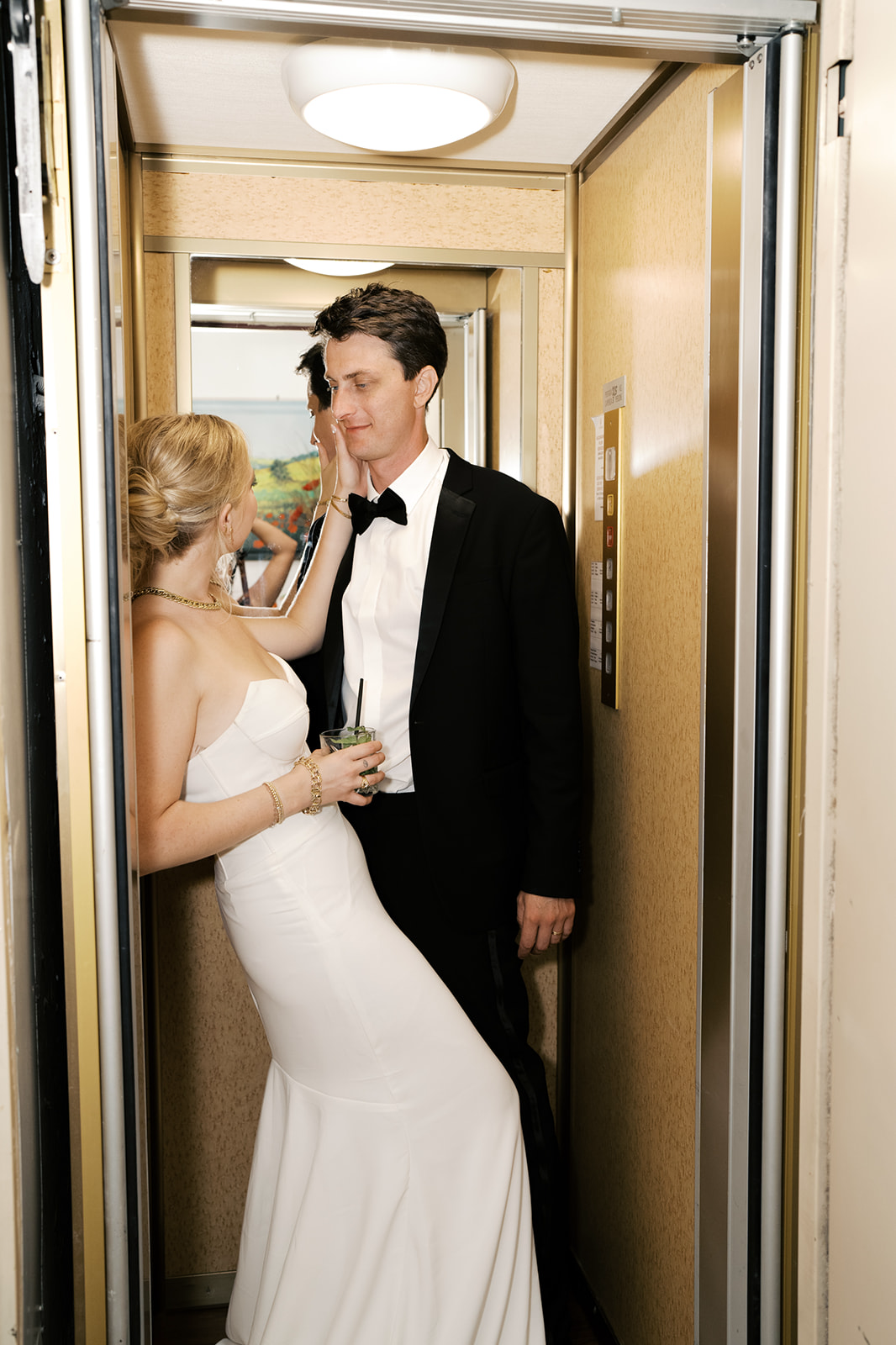 Bride caressing husbands face in the elevator during wedding reception | Megan Smith Photo