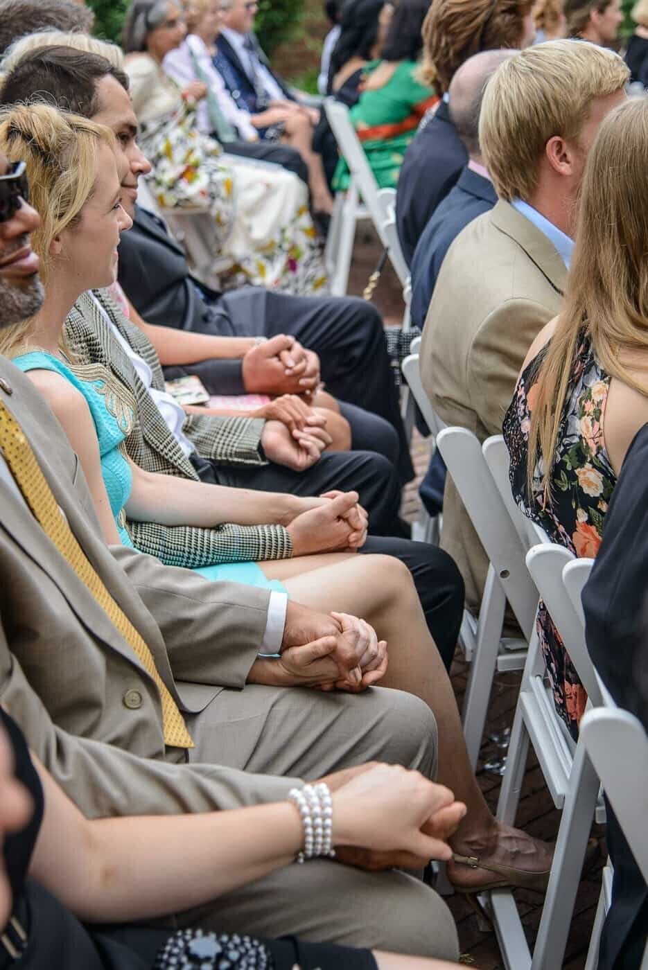 A row of wedding guests all holding hands during a wedding in Northern Virginia