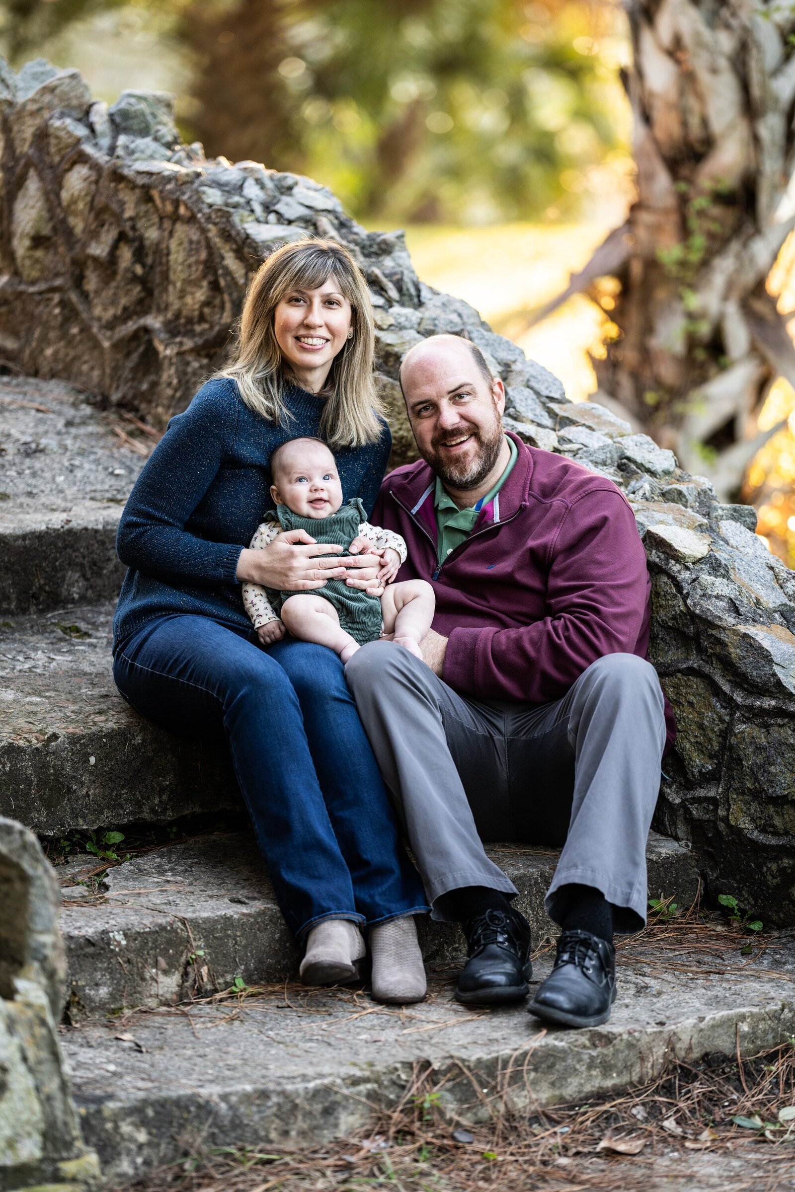 Couple and baby sitting on bridge in City Park