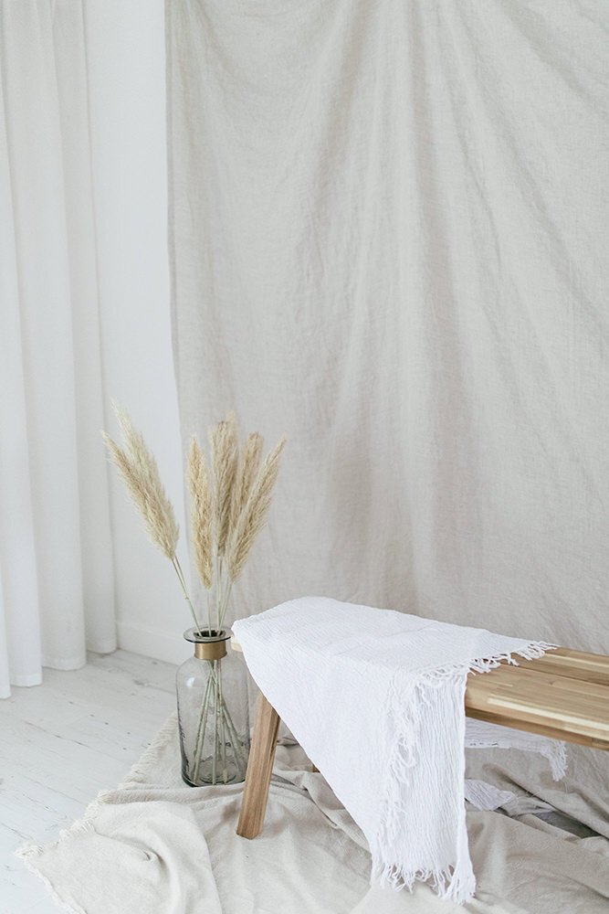 Bench with white fabric draped over it with flowers next to it