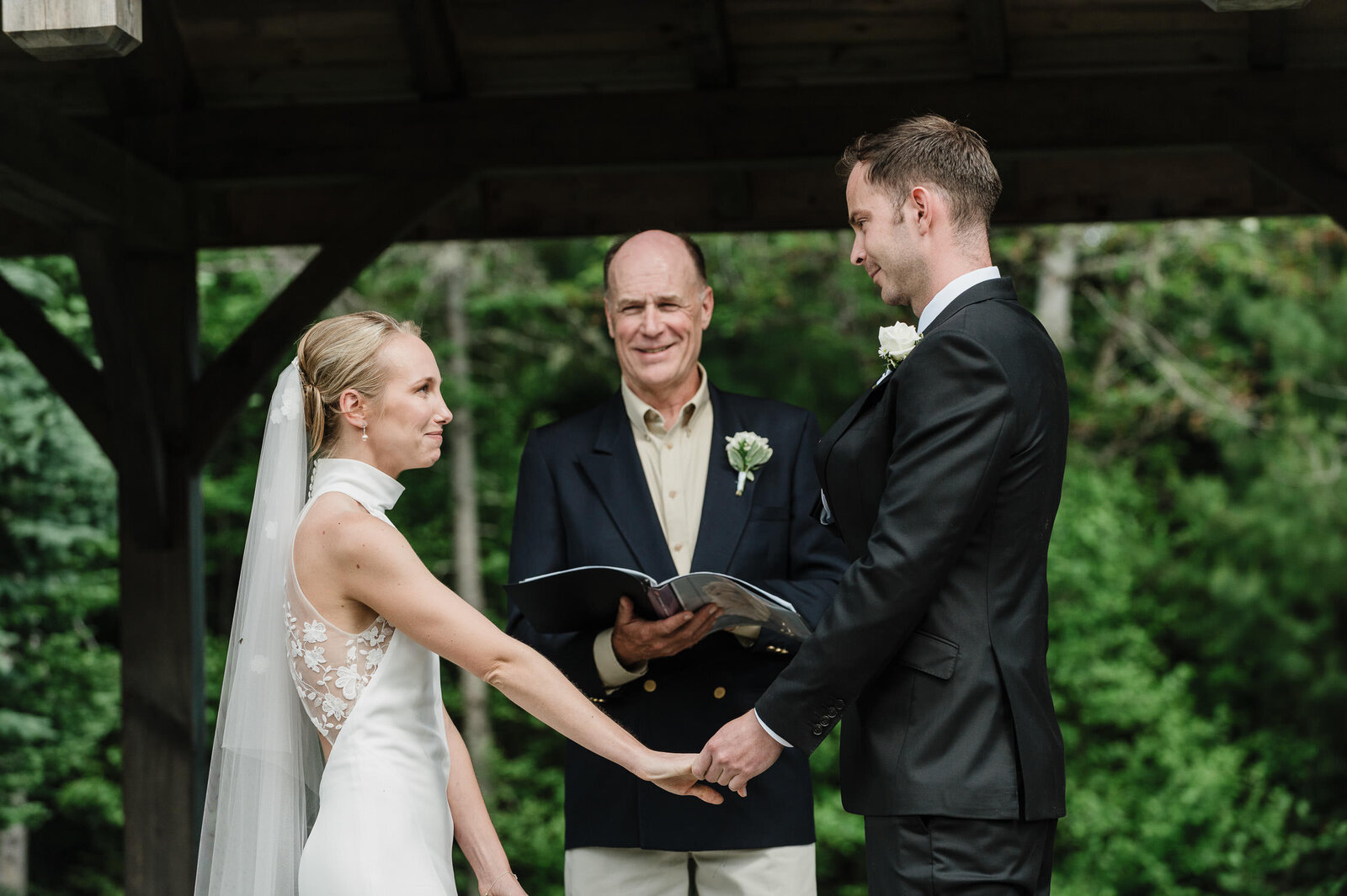 Emotional moment of couple getting married outside under a pavillion.