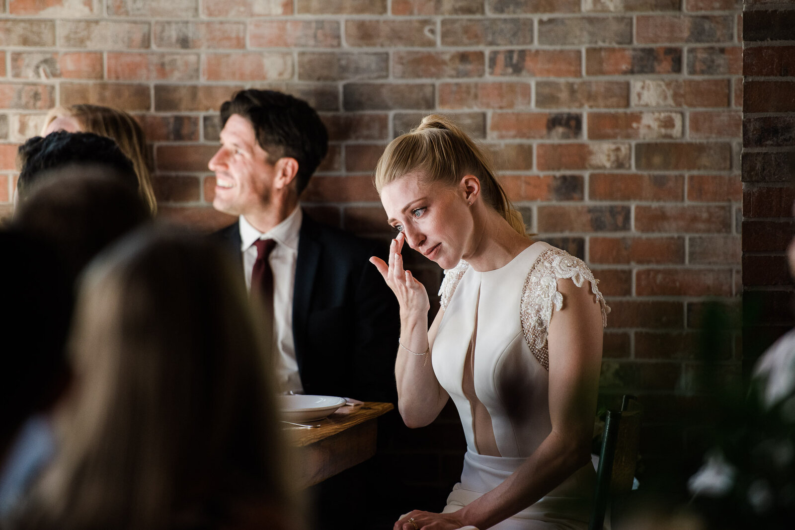 bride wipe tears at table during toasts