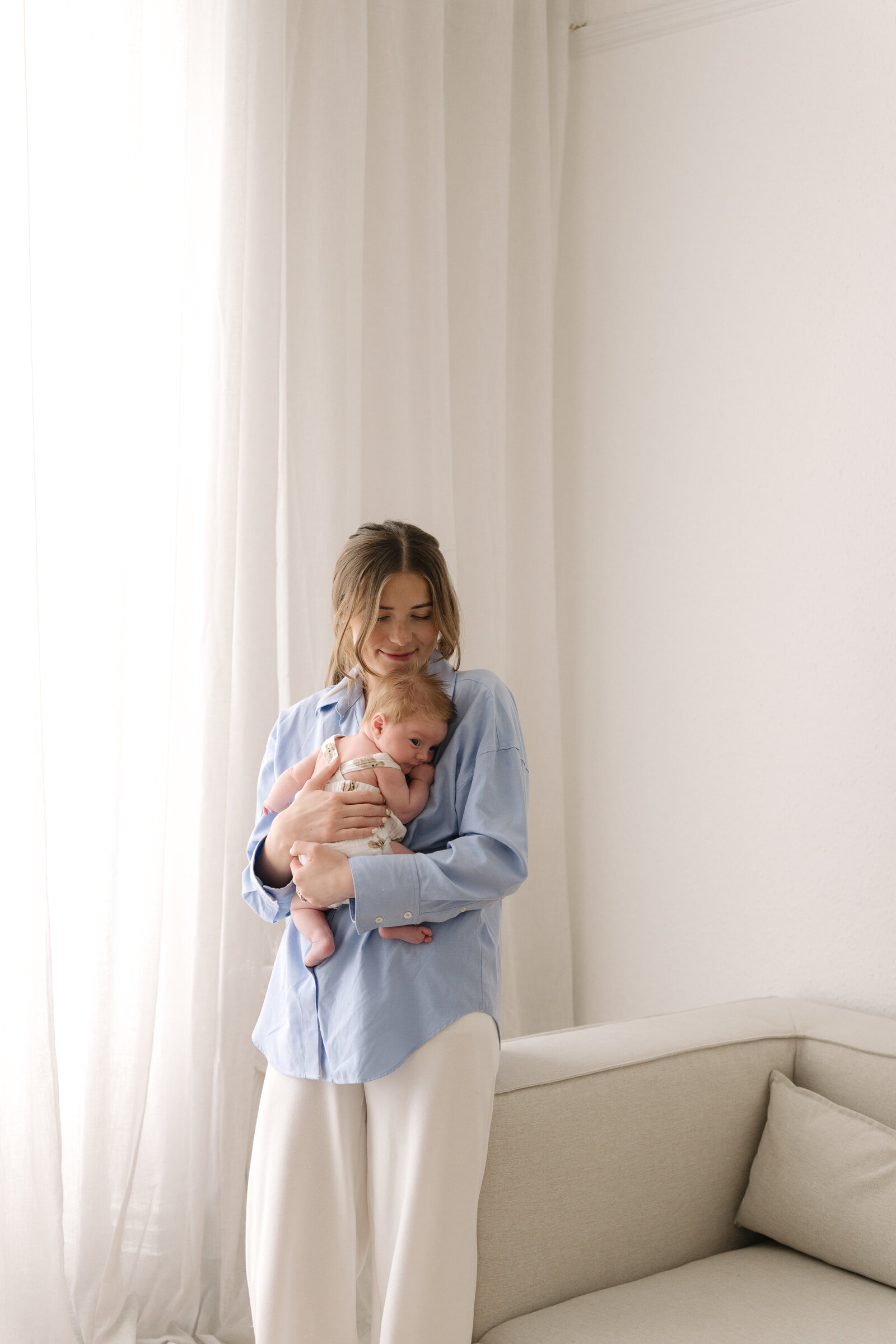Mother cuddles her newborn baby during her photography photoshoot
