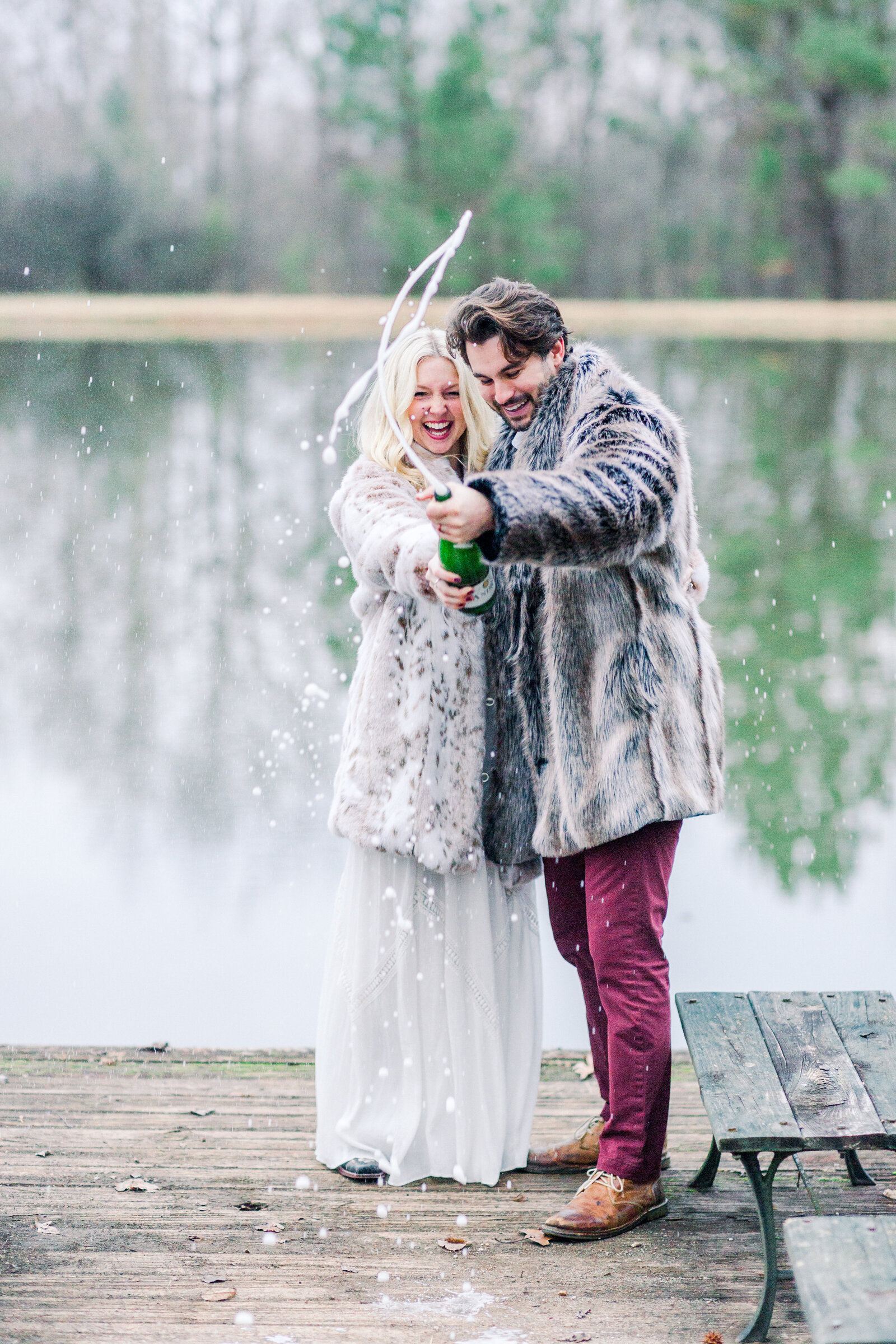 Popping champagne to celebrate their engagement captured by Staci Addison Photography