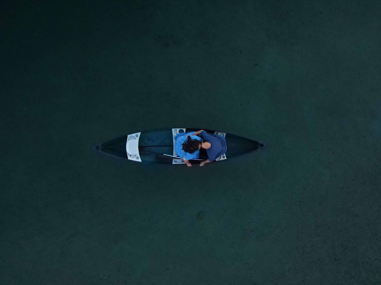 A drone photo of a couple in a canoe during their engagement photos on Redfish Lake in Idaho