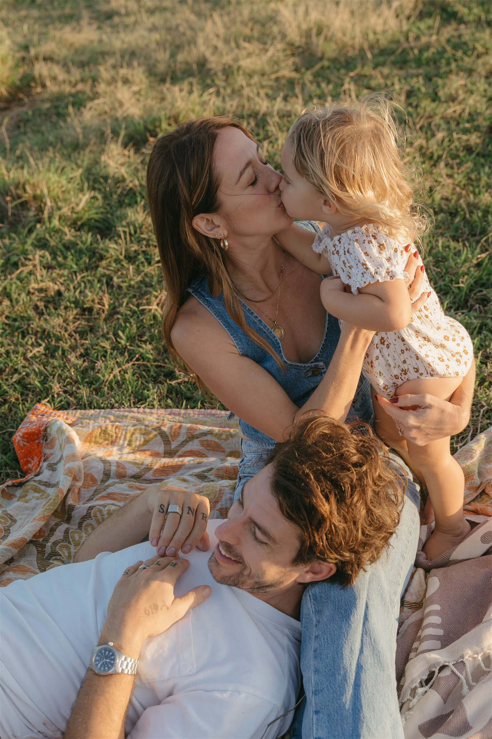 Mother and daughter embracing during a Maui family photo shoot, natural light highlighting denim and soft neutrals.