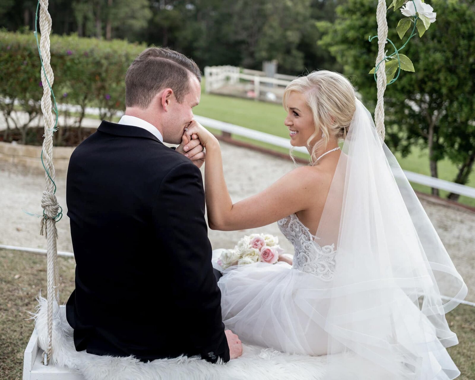 Bride and groom sitting on a swing at Austinvilla Estate