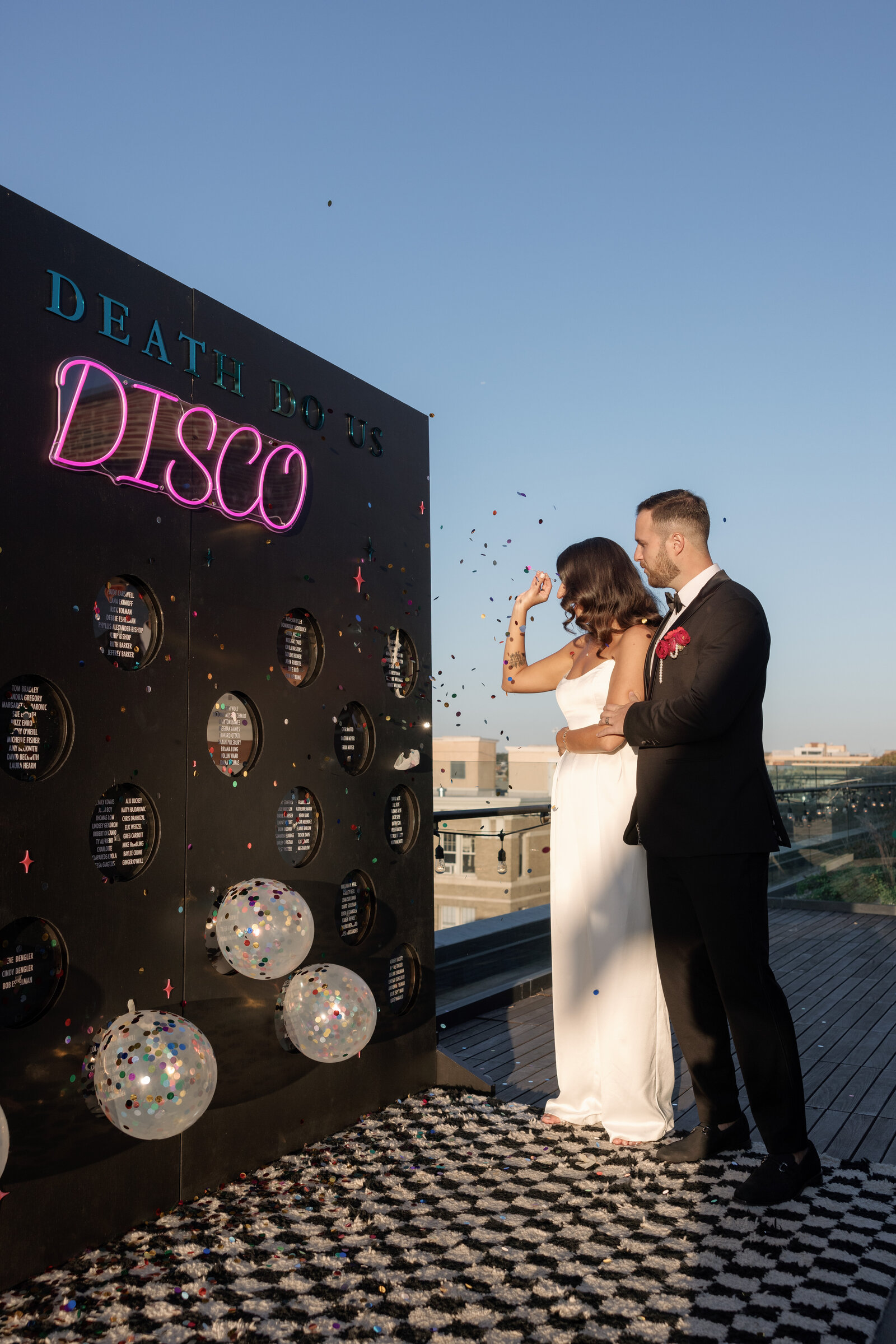 bride and groom popping a balloon escort wall for their wedding seating assignments