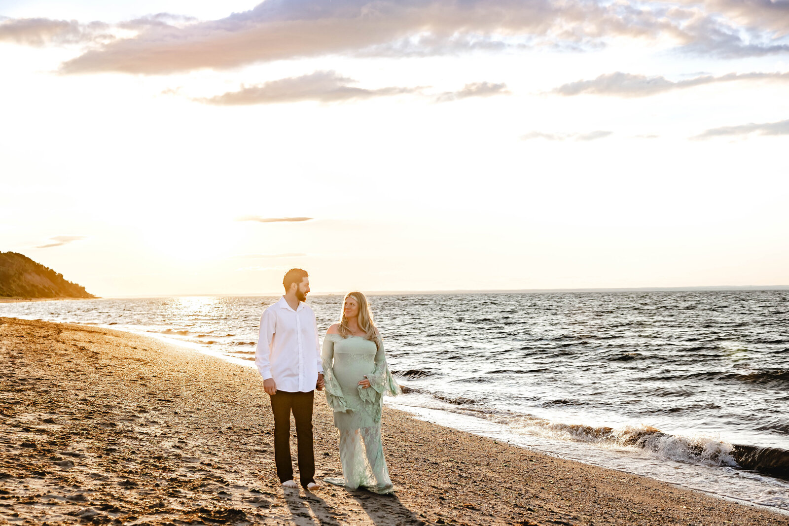 Suffolk County Maternity Photographer.   Sunken Meadow Park Maternity Photoshoot with couple walking along the beach