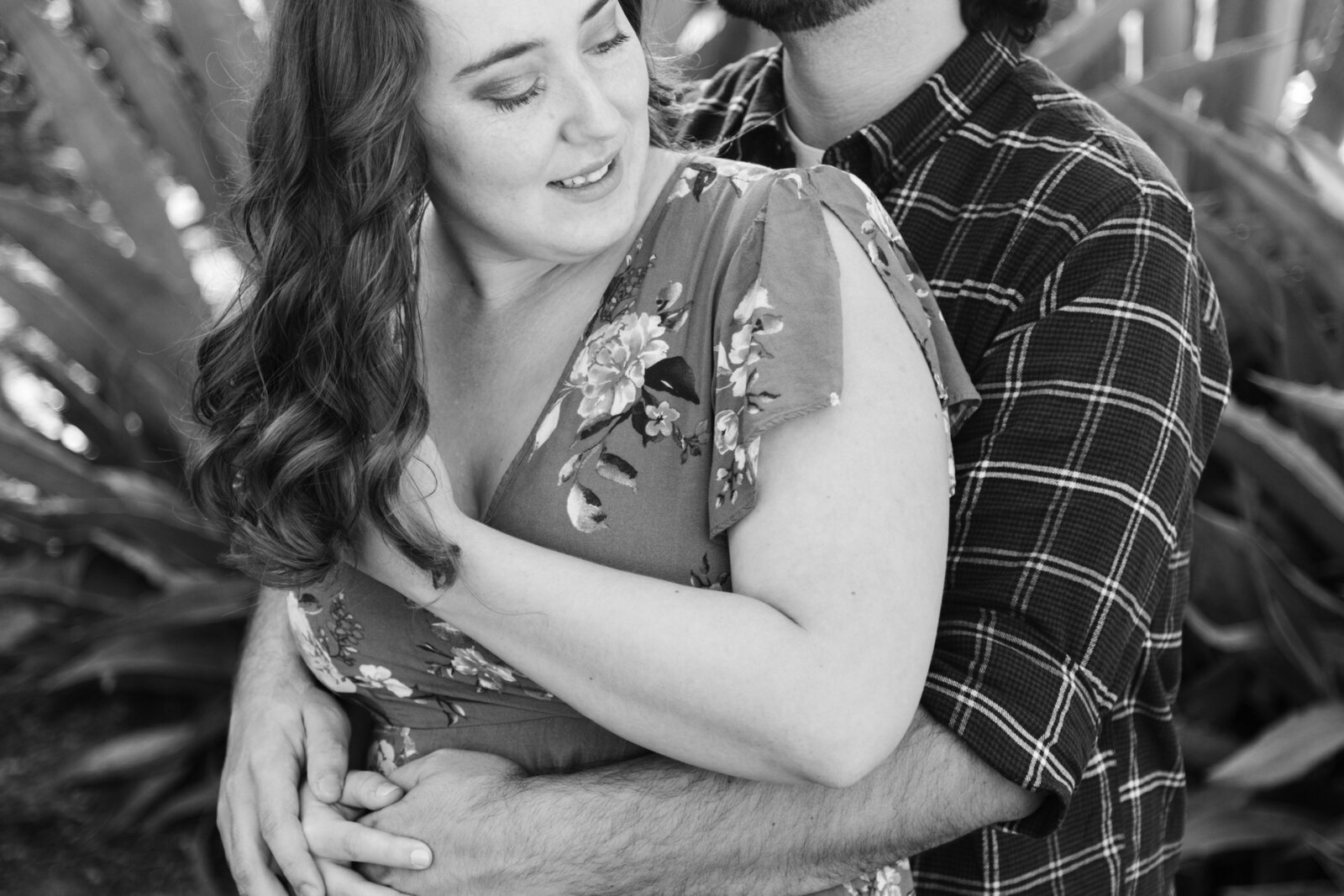 An engaged couple poses for photos in a garden in Los Angeles, Ca.