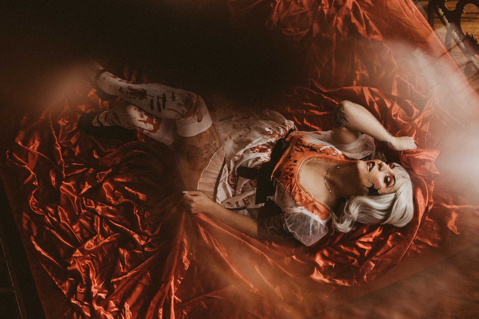 spooky looking woman laying on a red cloth 