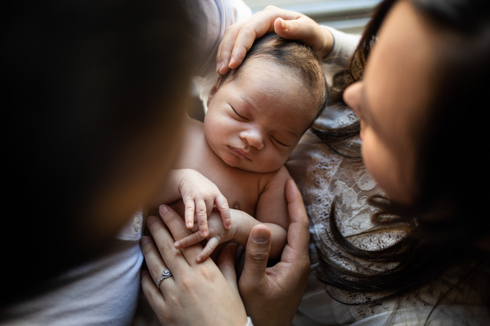 Kansas_City_Newborn_Photographer-parents_with_child_between_them_window_light_9