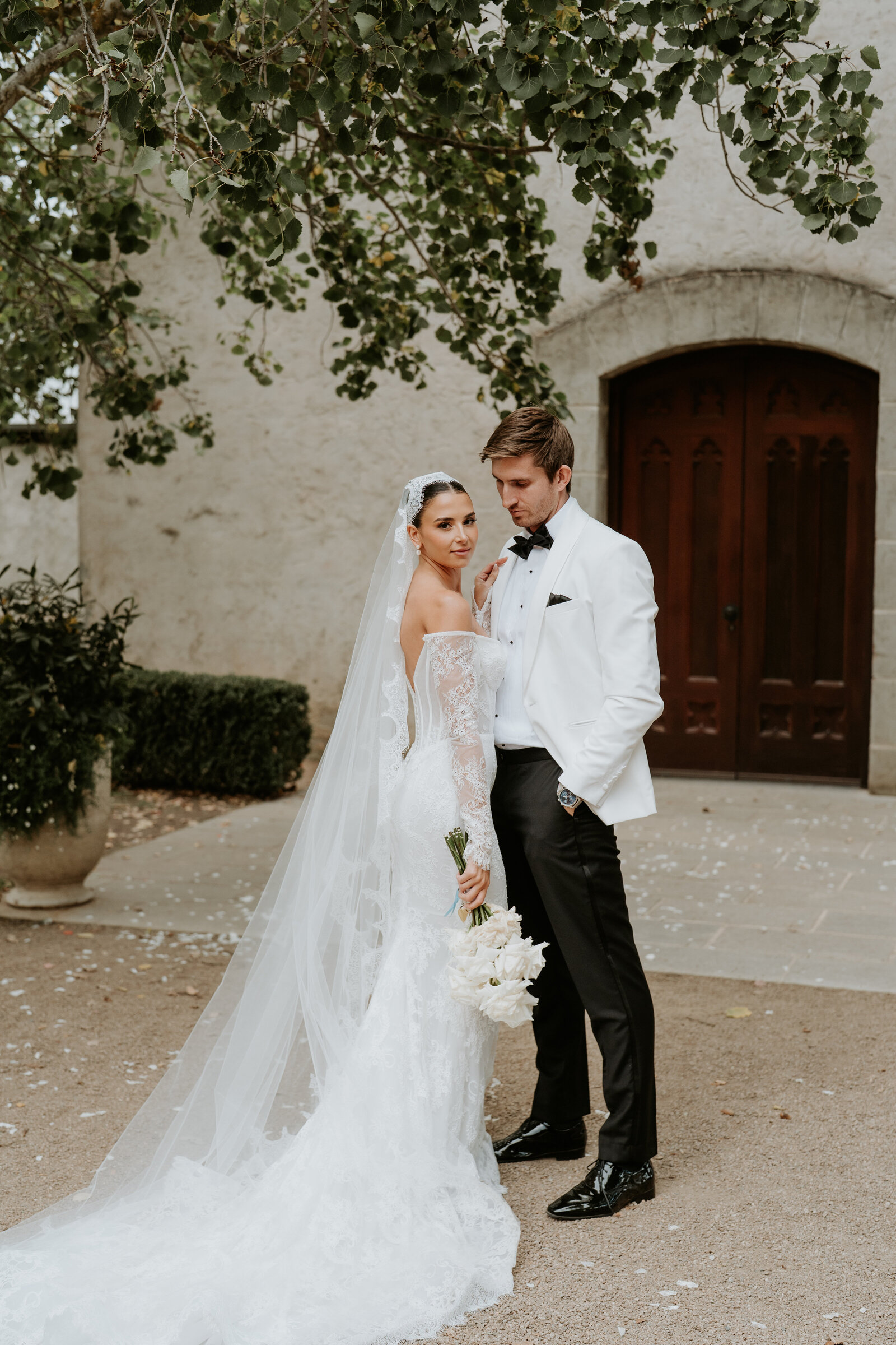 Bride and groom posing at entrance of the chapel