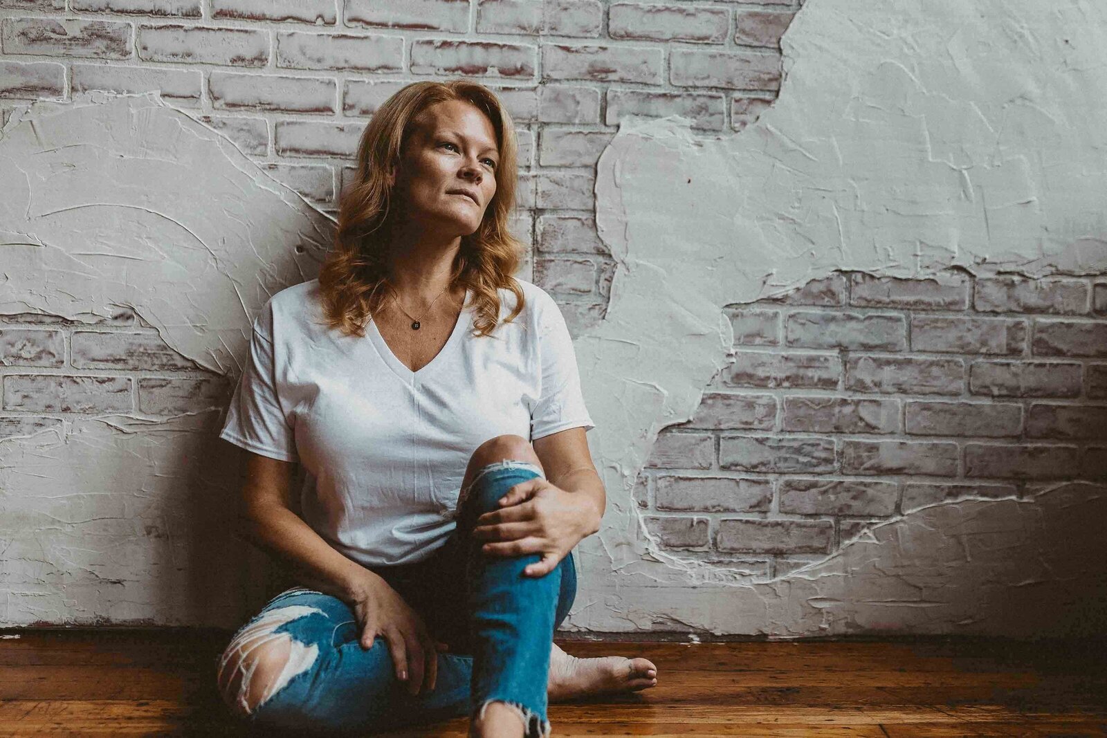 woman sitting on the floor and leaning on the wall