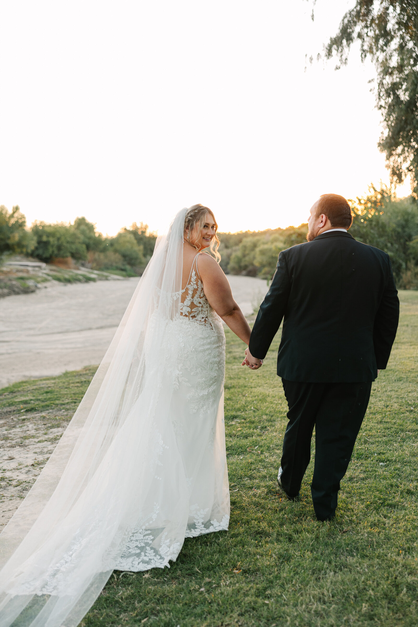 bride and groom walking into the sunset