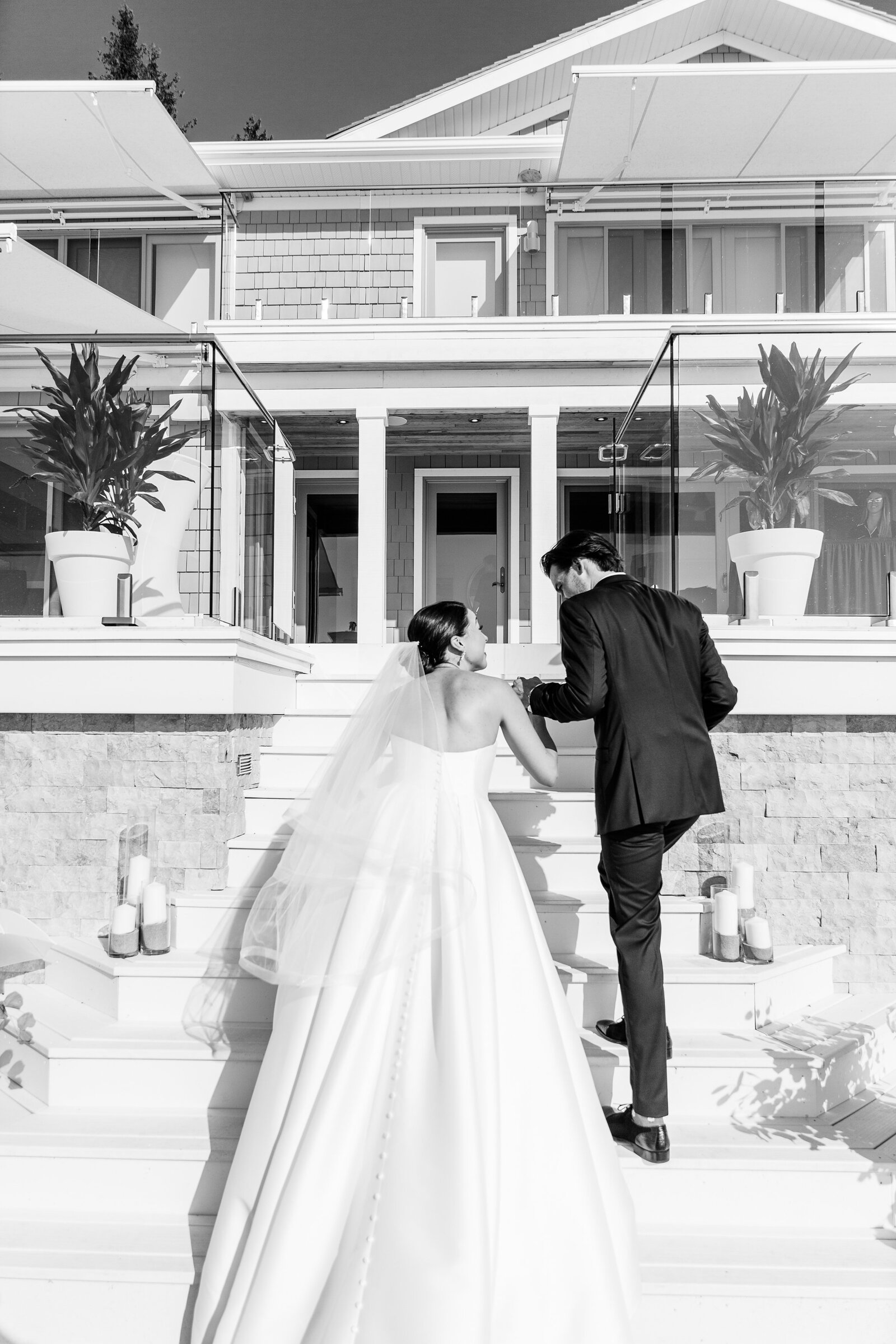 After their wedding ceremony in Zurich ontario bride and groom go up the steps of their beach house to celebrate