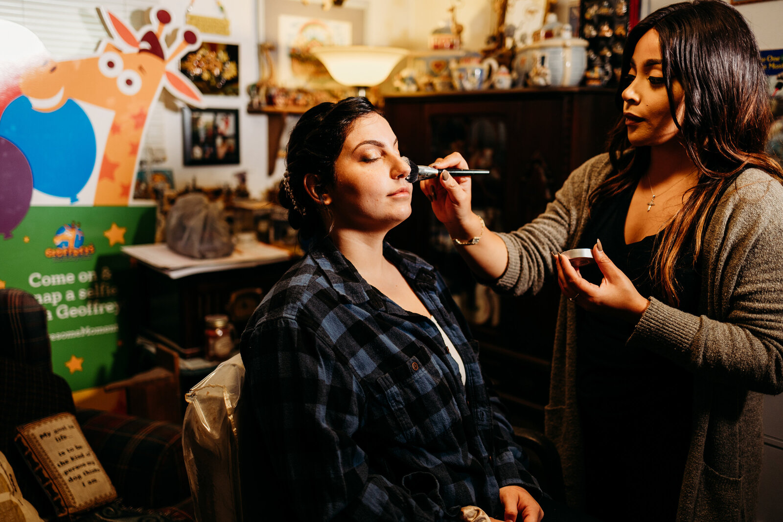 Bride sits patiently as her makeup artist applies her wedding day makeup look