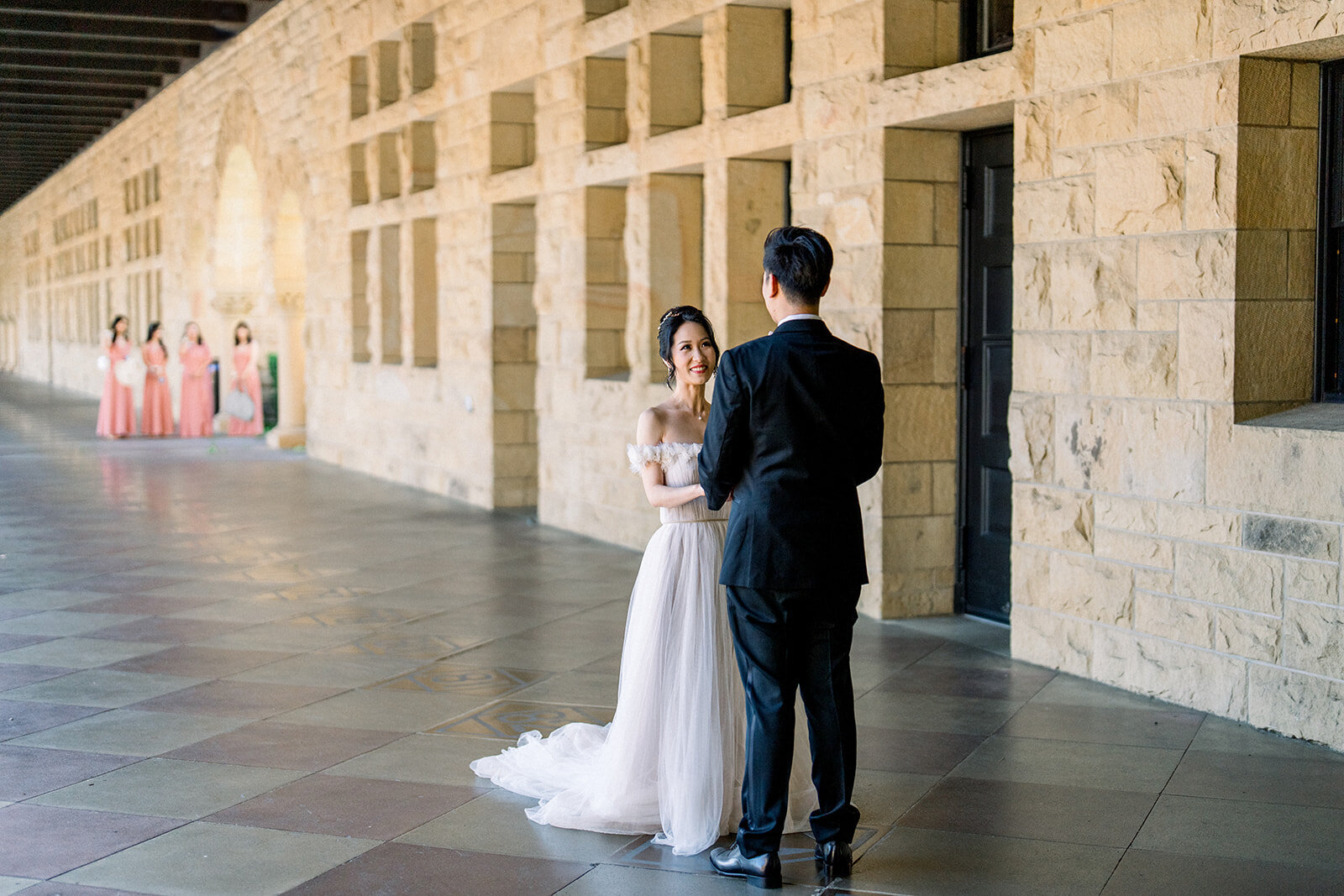 The bride and groom take a romantic stroll through the historic corridors of Stanford University, capturing a serene and intimate moment.