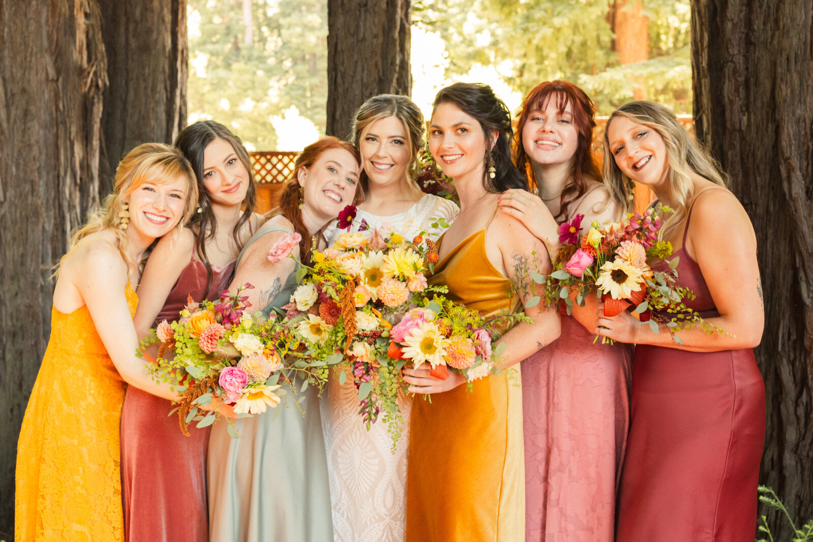 Bride and bridesmaid at her colorful wedding ceremony in Santa Cruz, California in the redwood trees.