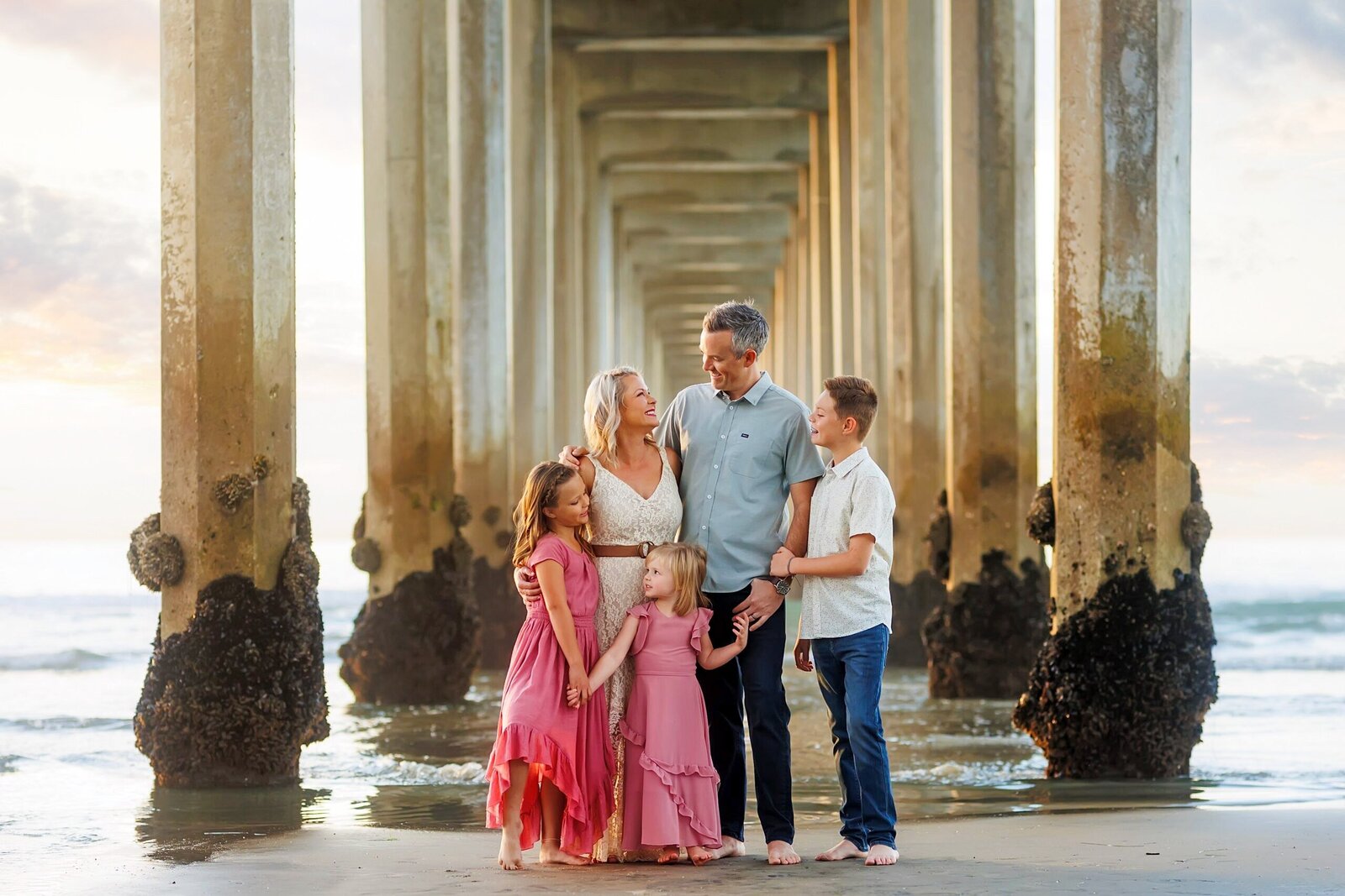 Beautiful family posing for a photo under Scripps Pier