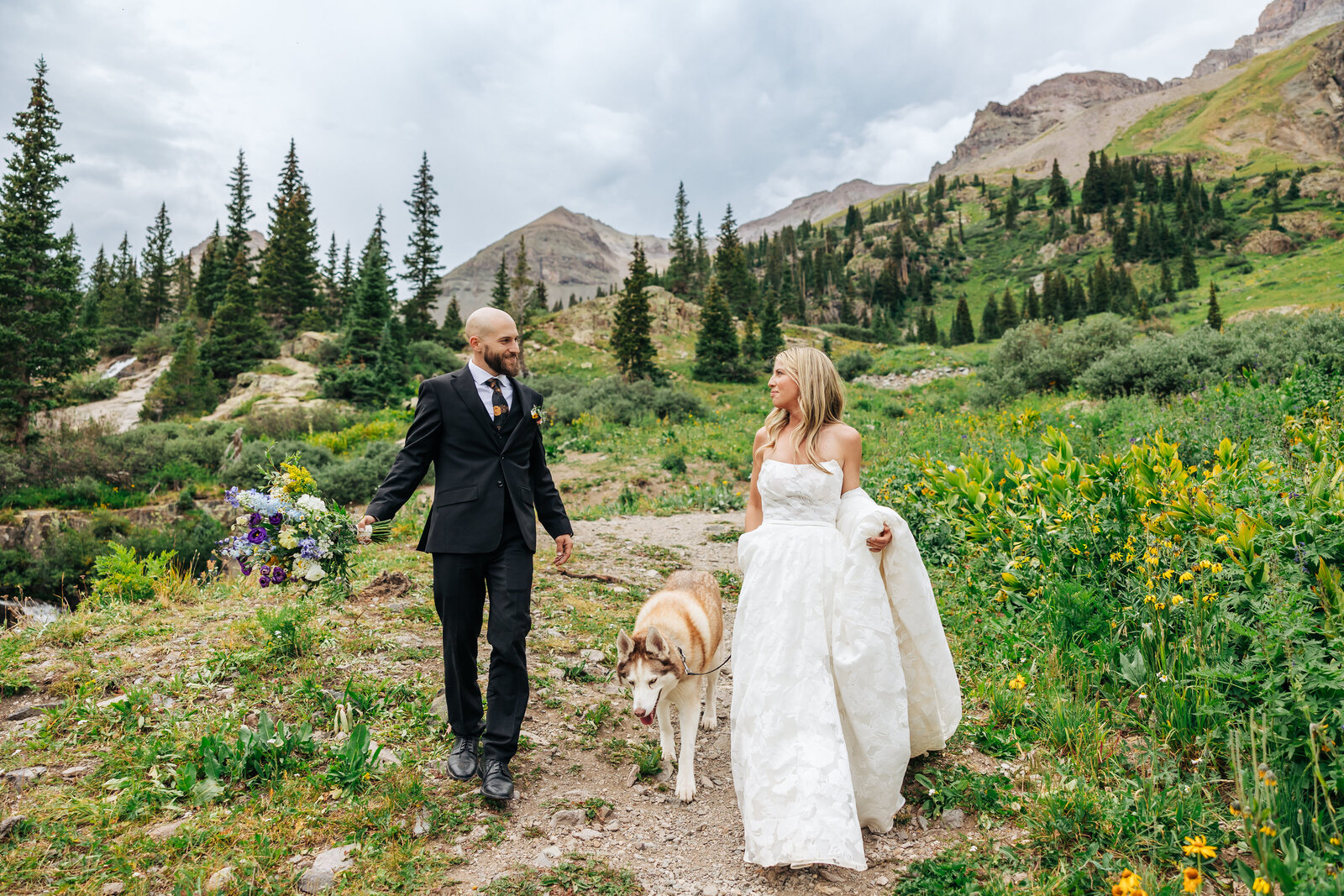 Boulder Wedding Photographer captures bride and groom holding hands and walking dog